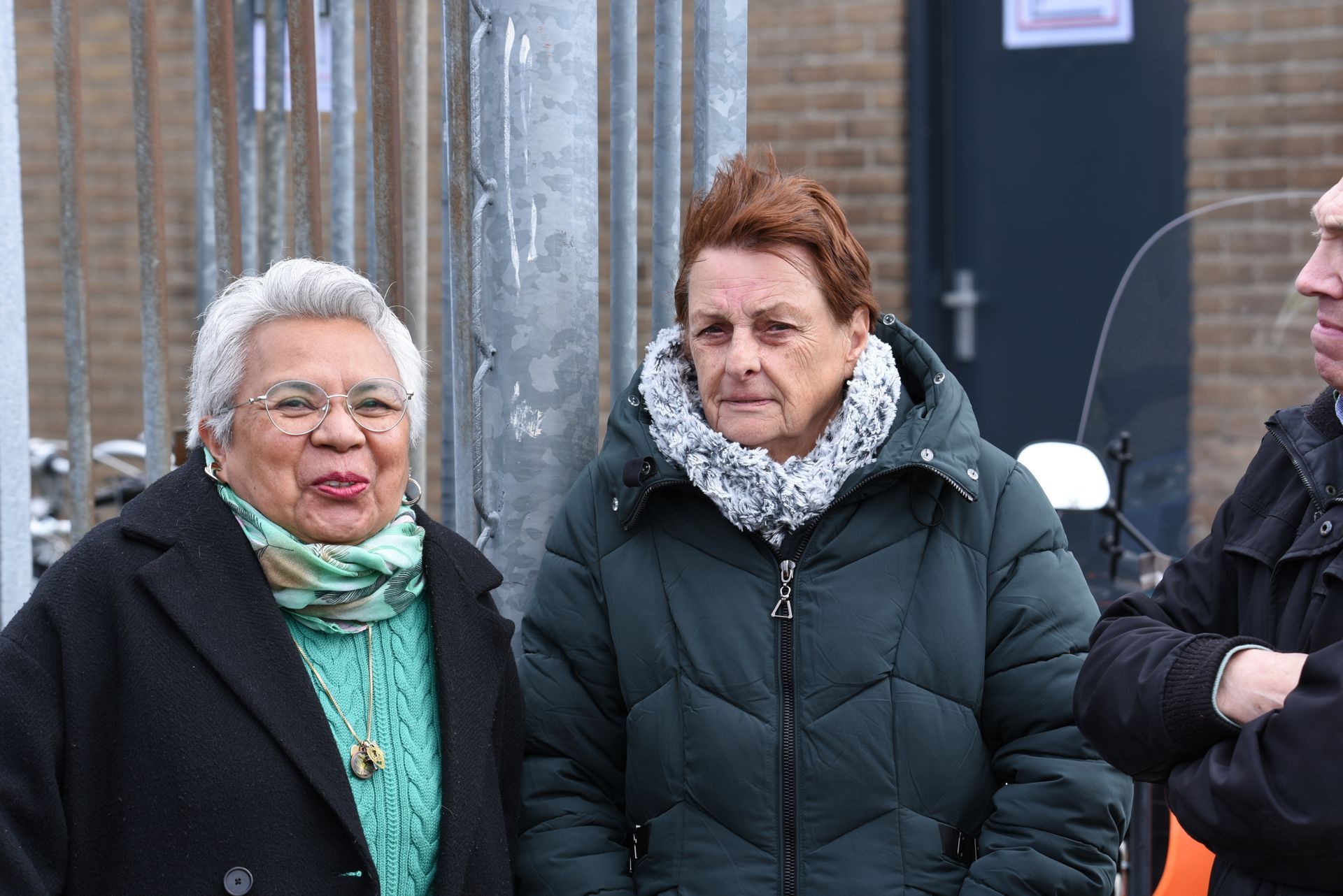 Voor een gebouw staan ​​drie vrouwen naast elkaar.
