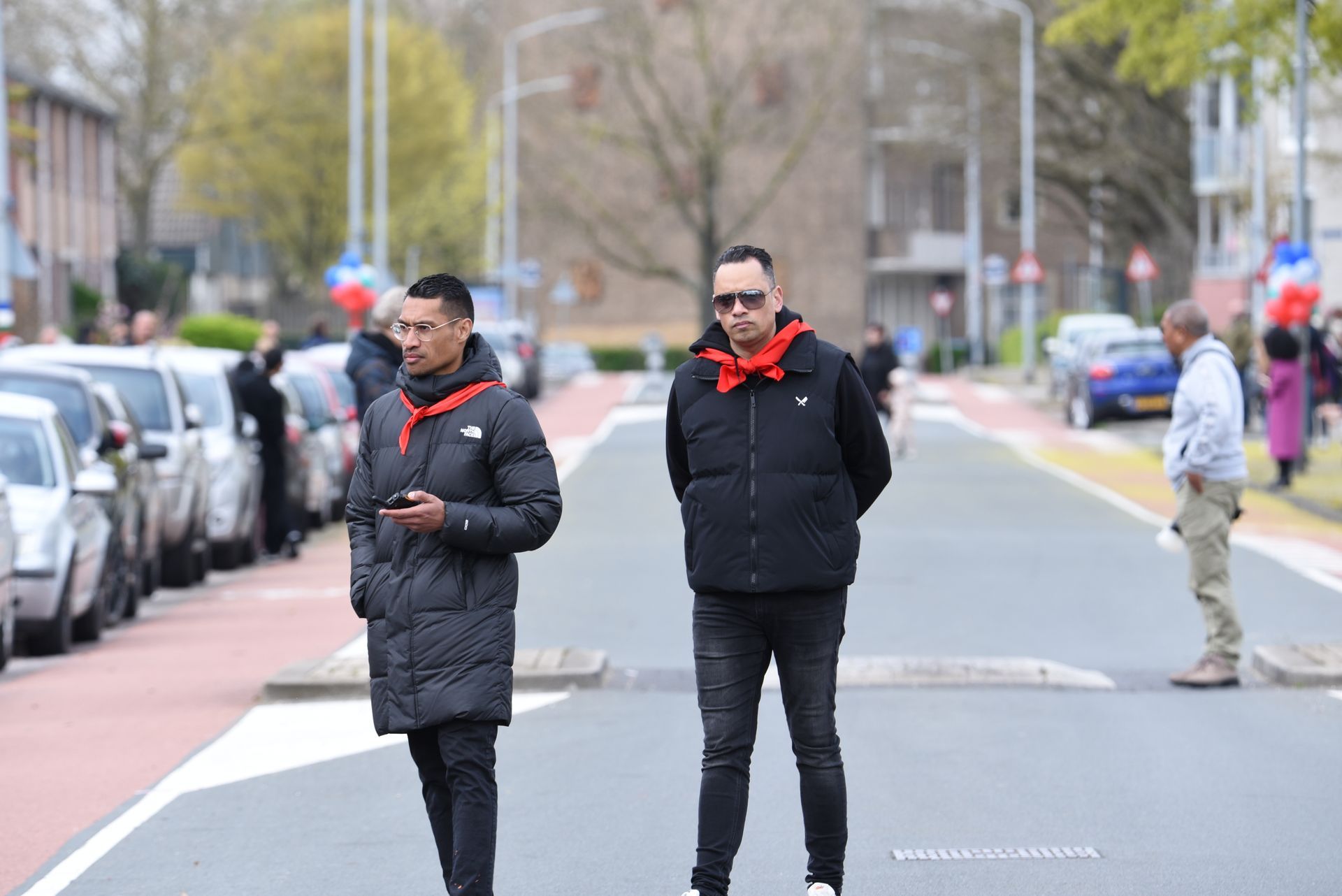 Twee mannen staan ​​aan de kant van een straat.