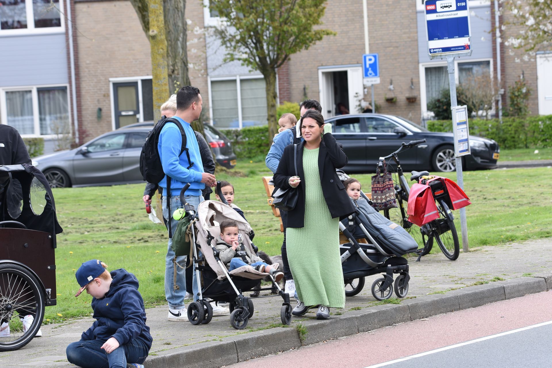 Een groep mensen staat langs de kant van de weg.