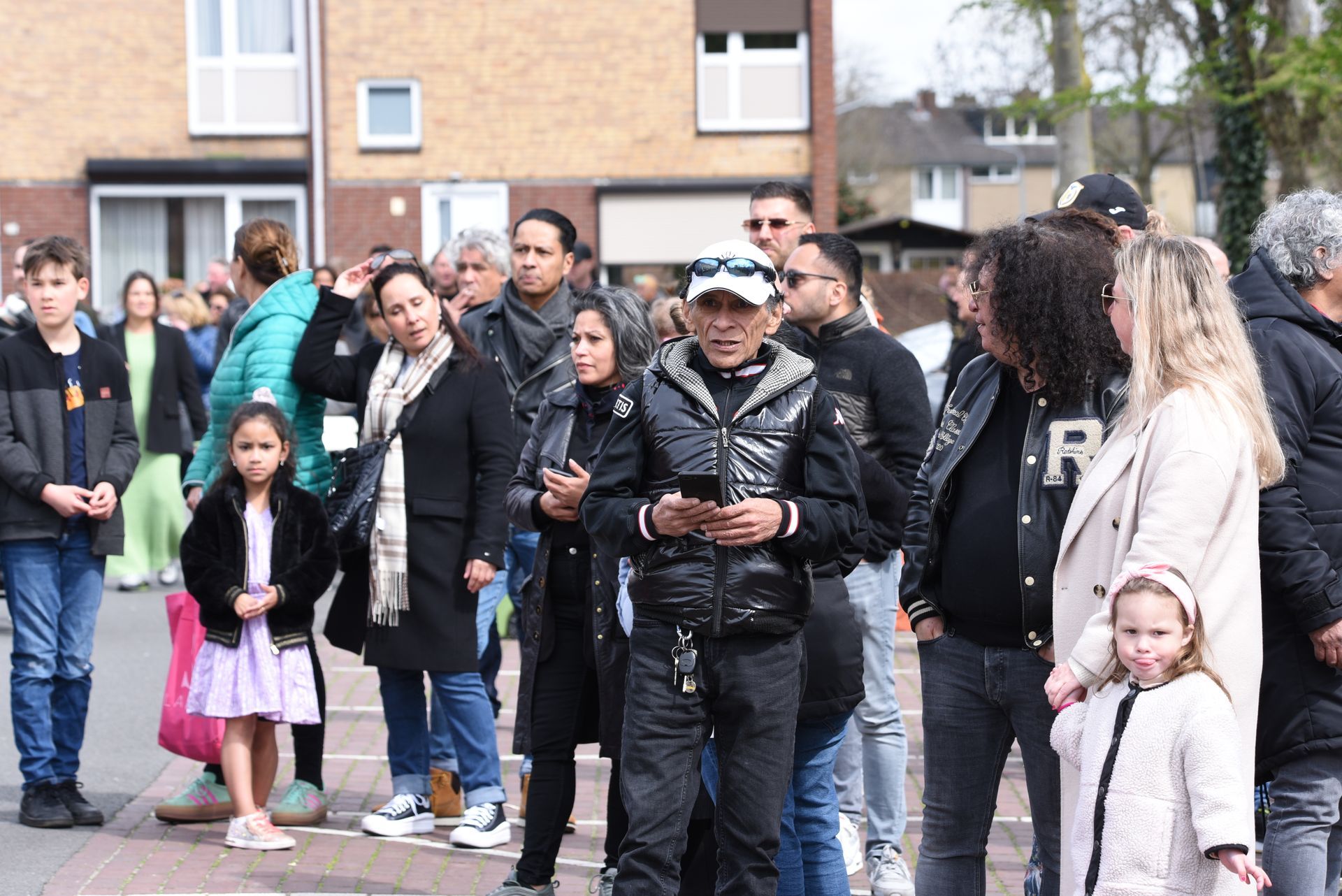 Een groep mensen staat op de stoep voor een gebouw.