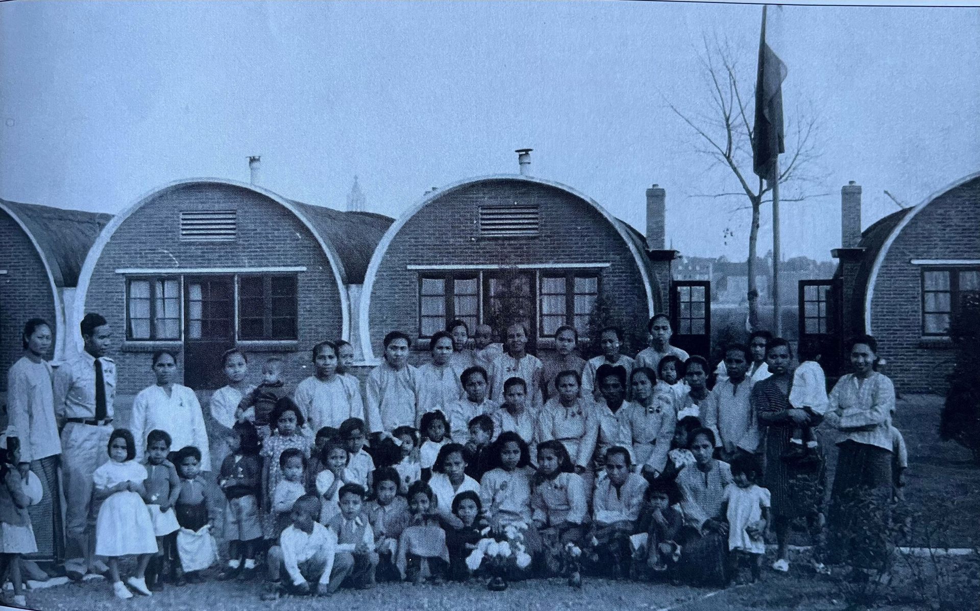 Een groep mensen poseert voor een foto voor een huizenrij