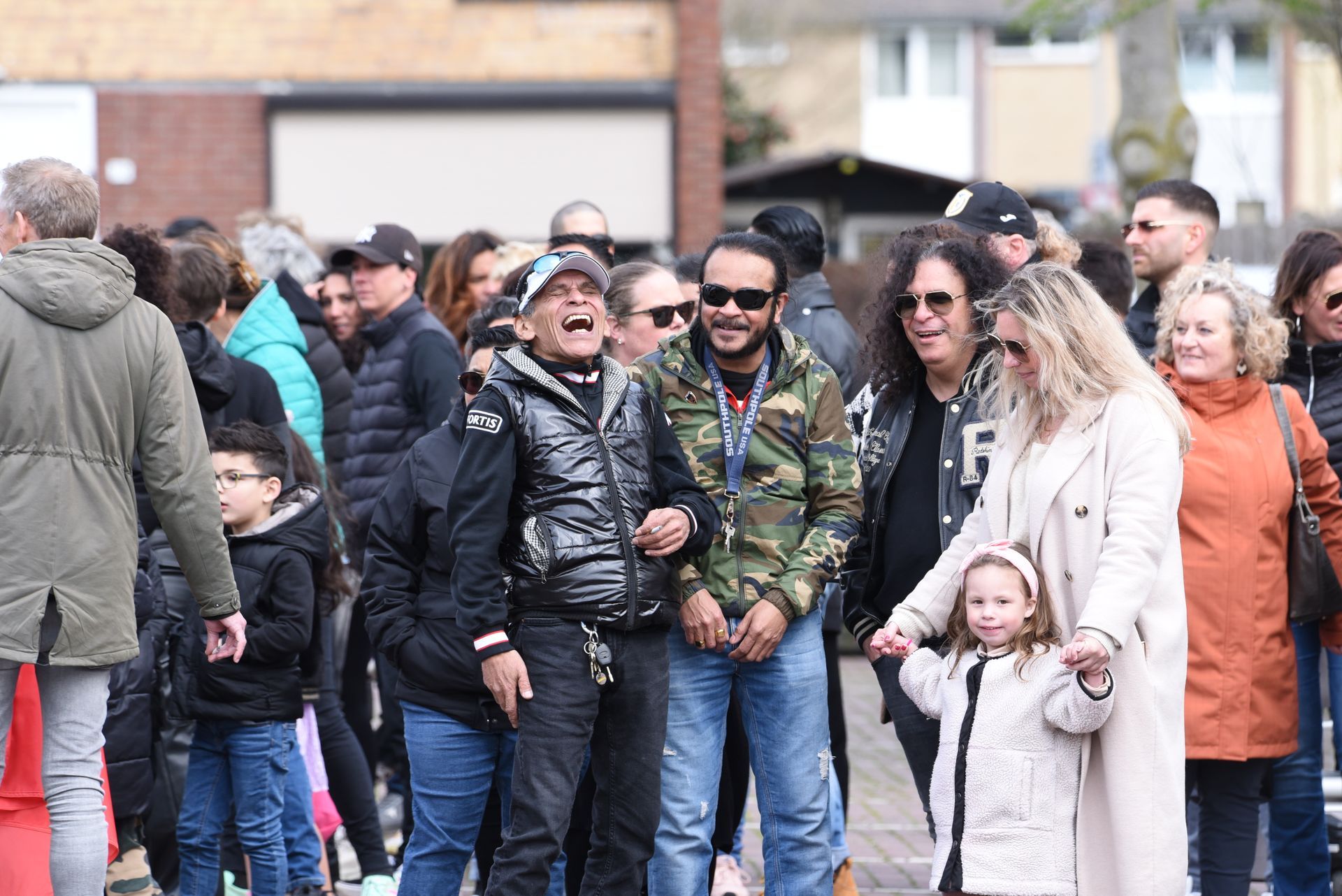 Een grote groep mensen loopt door een straat.