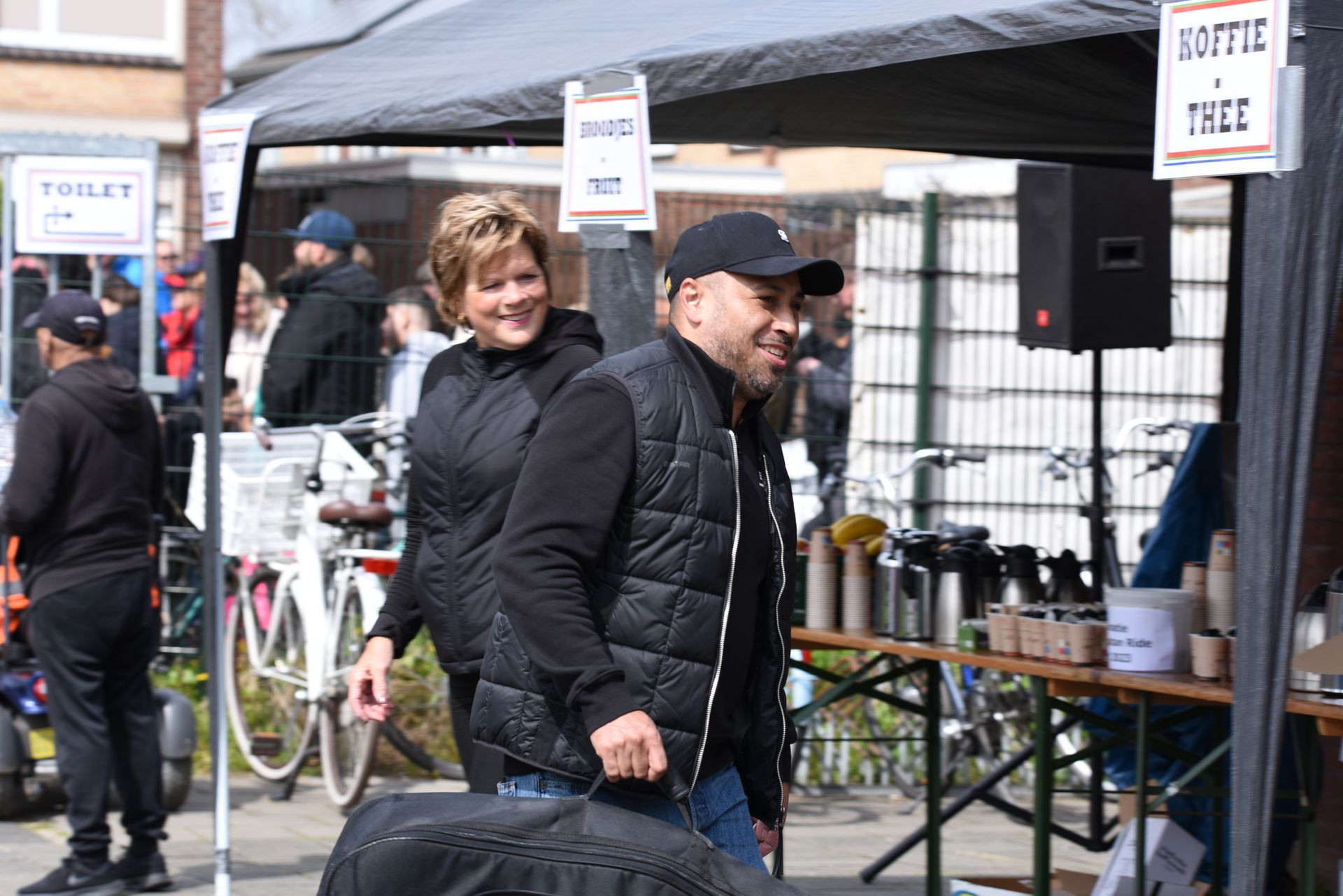 Een man en een vrouw staan ​​voor een tent.