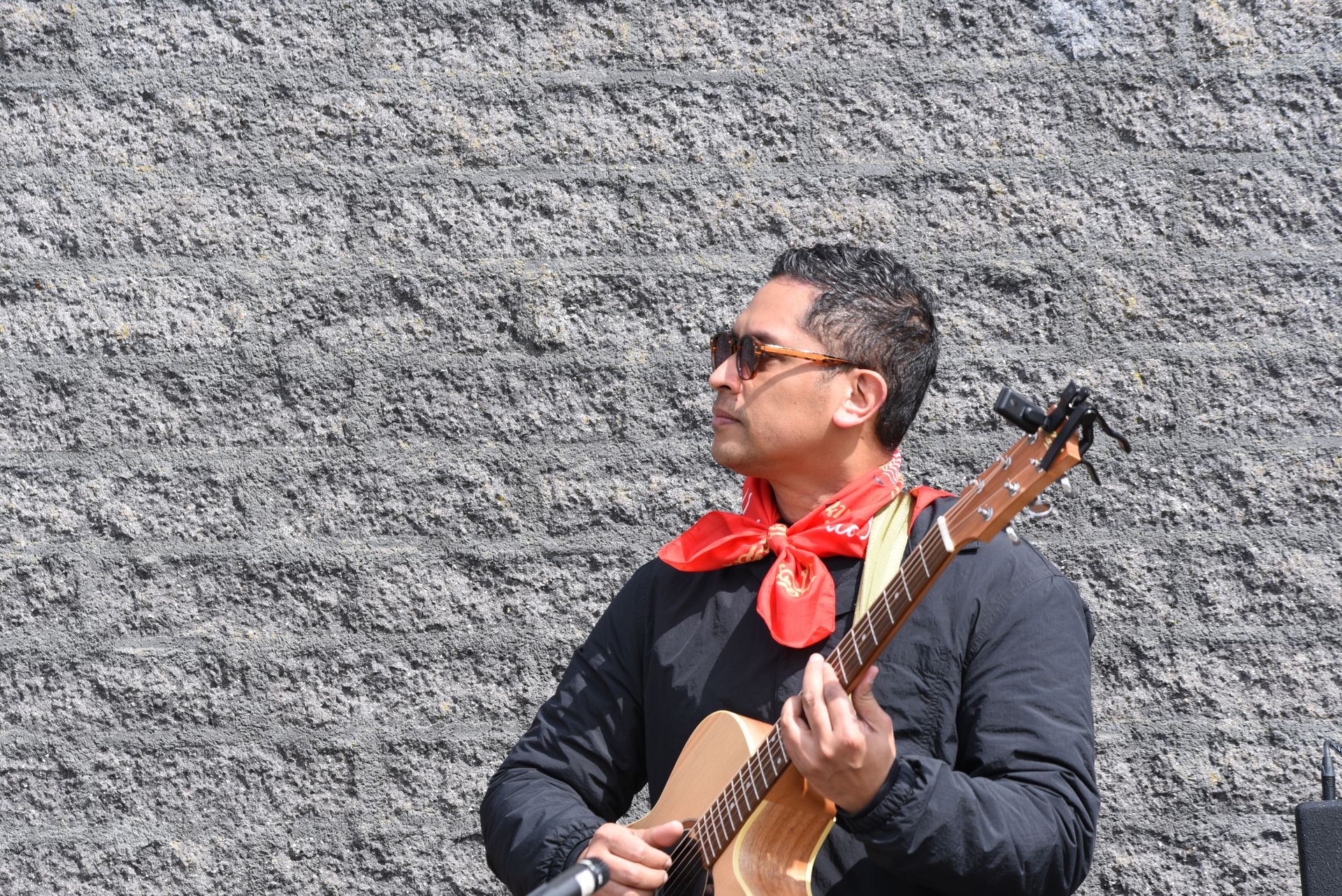 Een man met een rode sjaal speelt gitaar