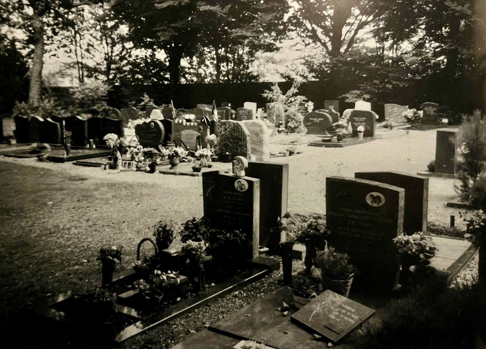 Een zwart-witfoto van een begraafplaats met veel graven