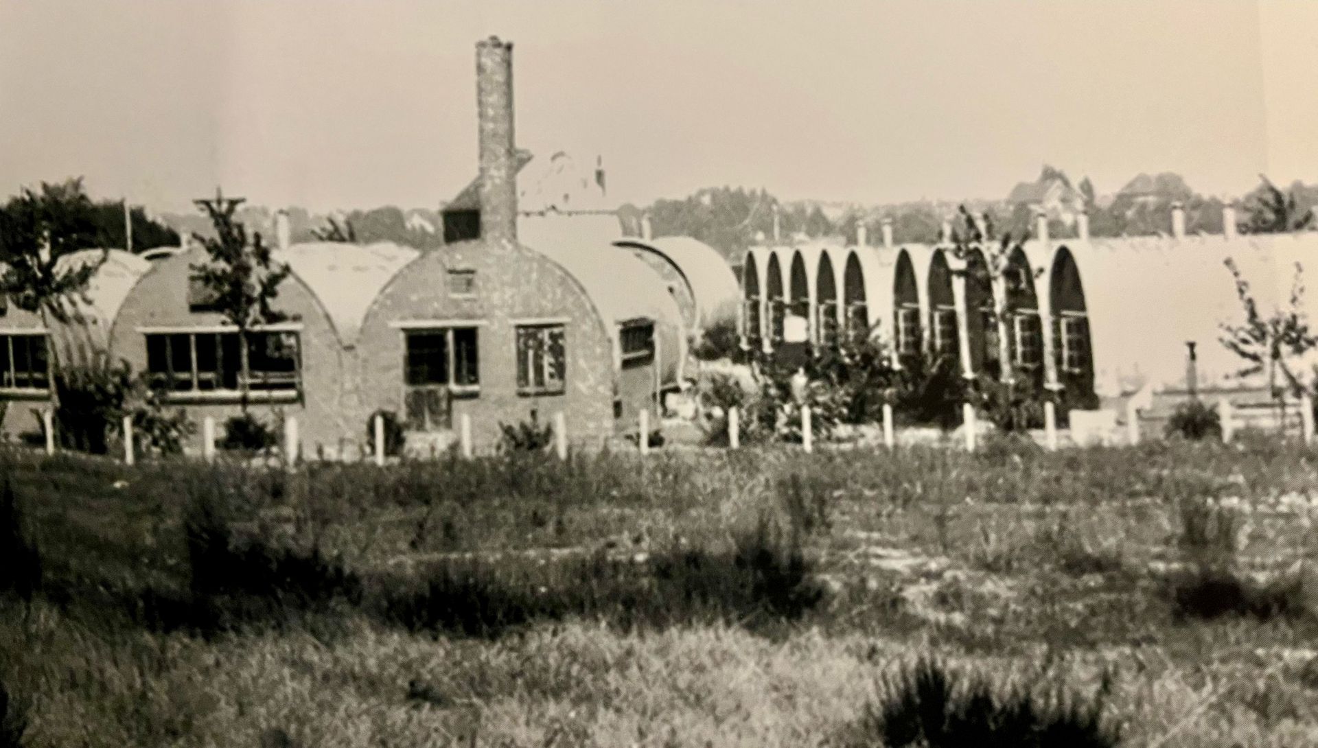 Een zwart-witfoto van een huis midden in een veld.
