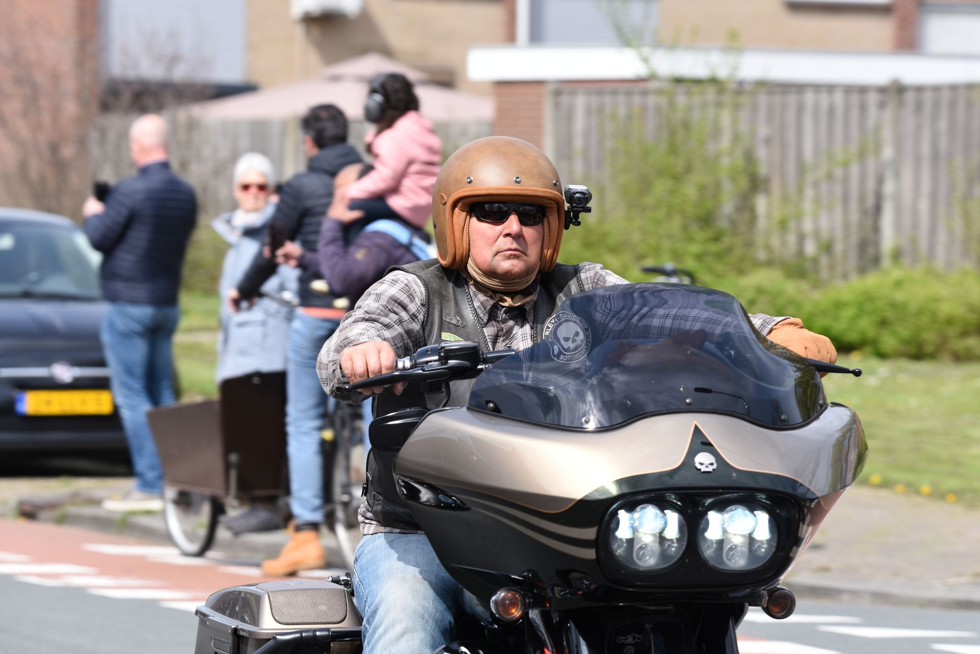 Een man rijdt op een motorfiets door een straat.