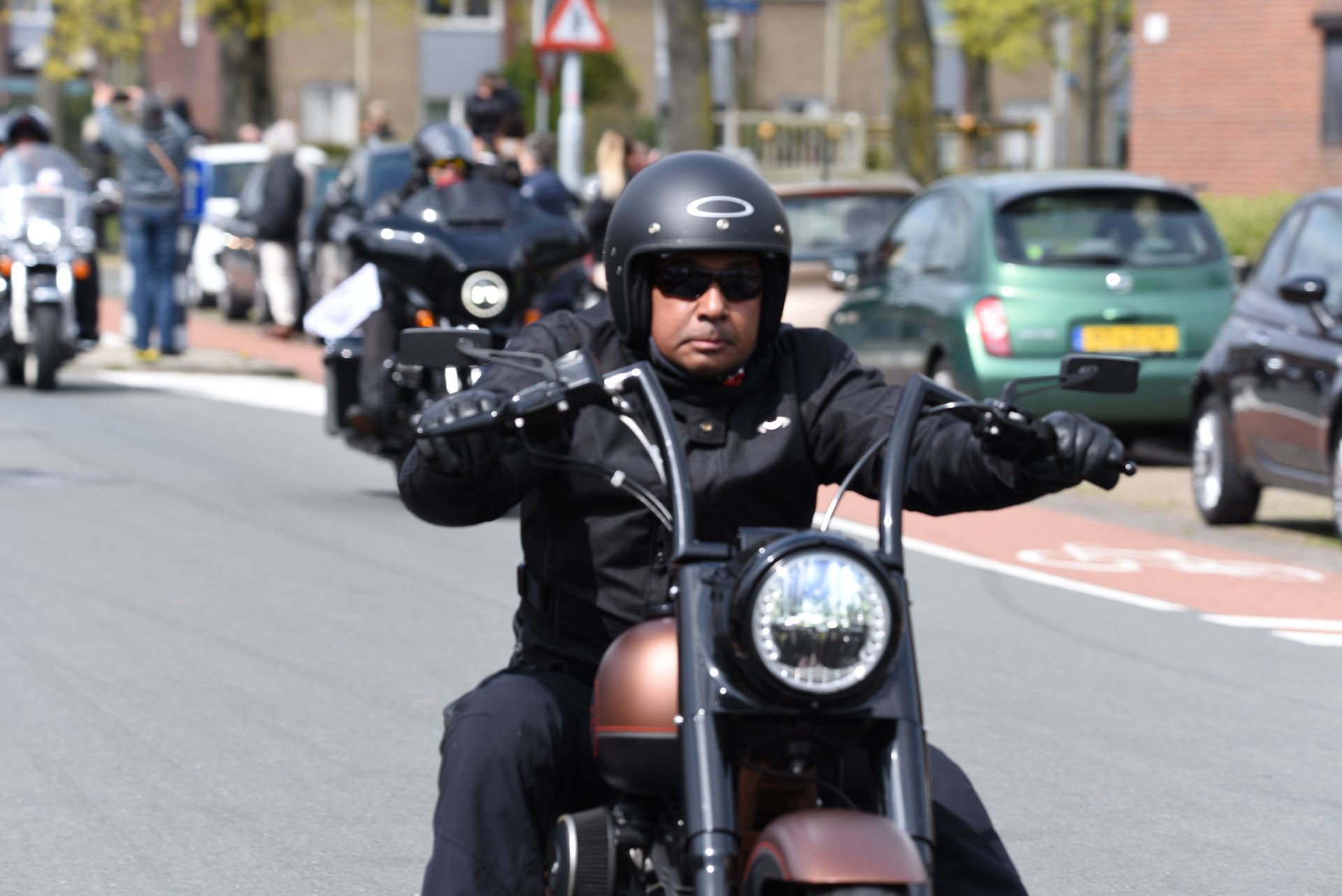 Een man rijdt op een motorfiets door een straat.