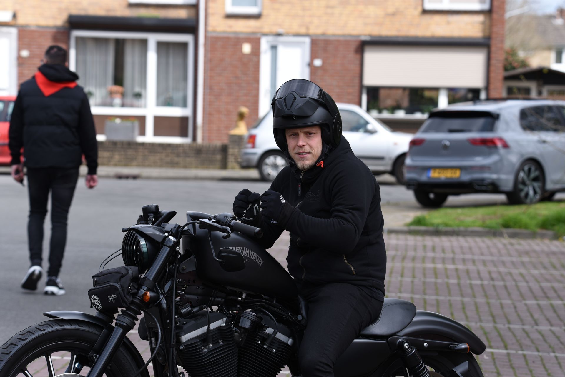 Een man zit op een motorfiets en draagt ​​een helm.