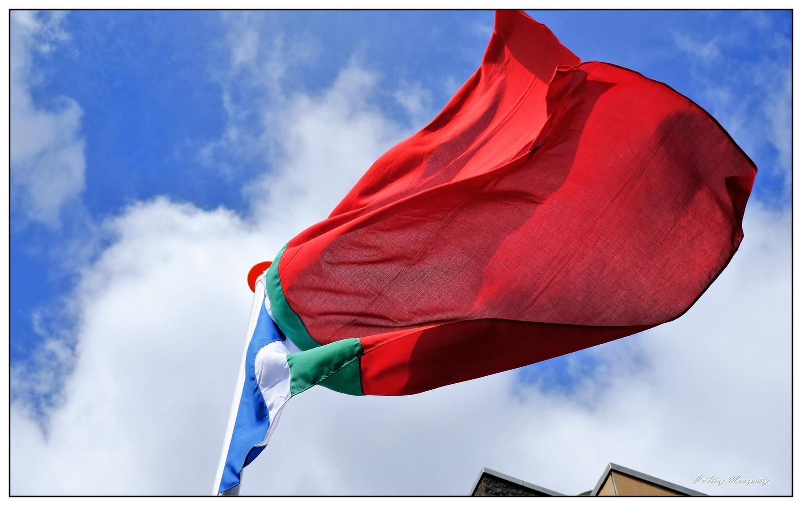 Een roodgroene en blauwe vlag wappert in de wind