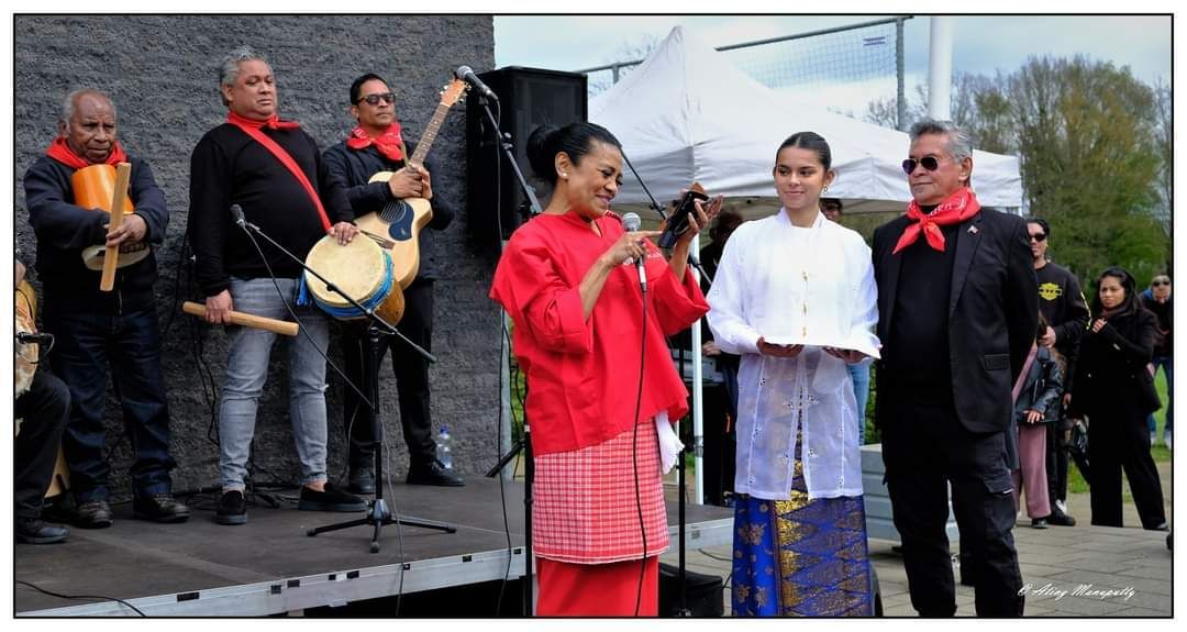 Een groep mensen staat op een podium en bespeelt instrumenten.