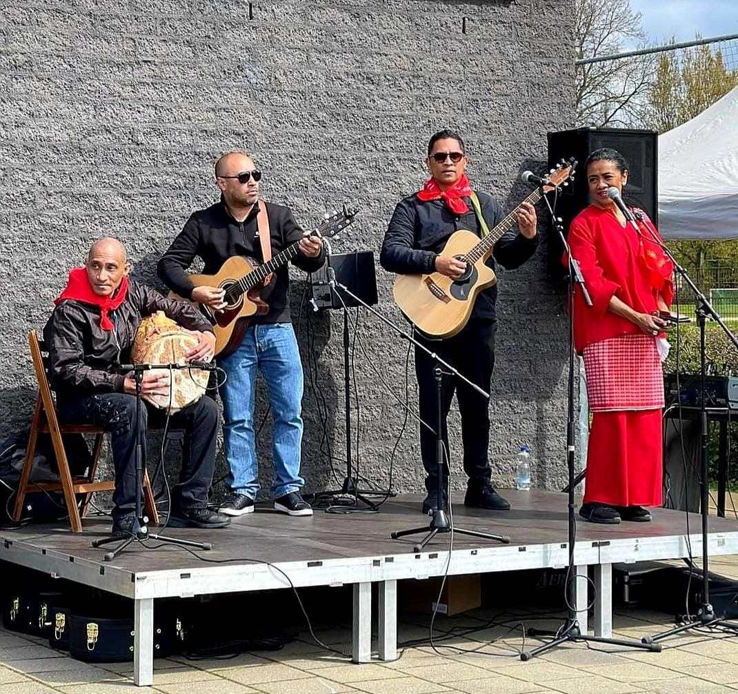 Een groep mensen bespeelt instrumenten op een podium.