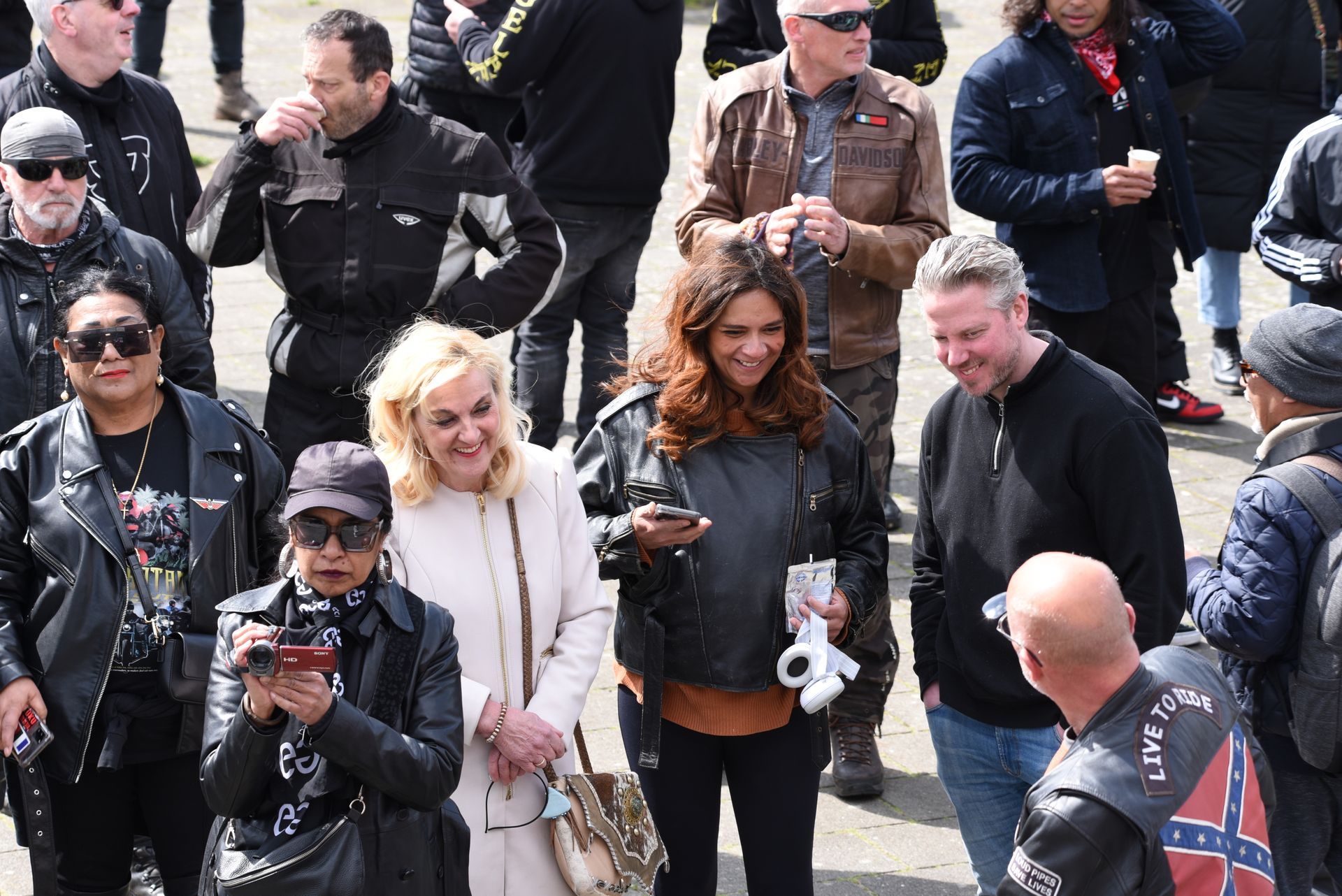 Een groep mensen die in een menigte naast elkaar staan.