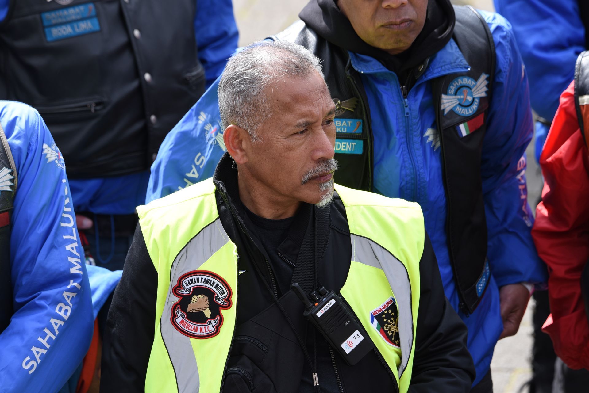 Een man die een geel vest draagt ​​met het woord sahabat erop