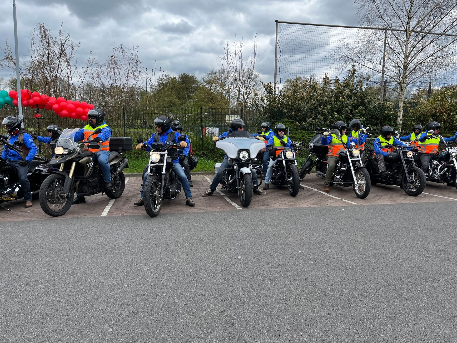 Een groep mensen rijdt op een motorfiets op een parkeerplaats.