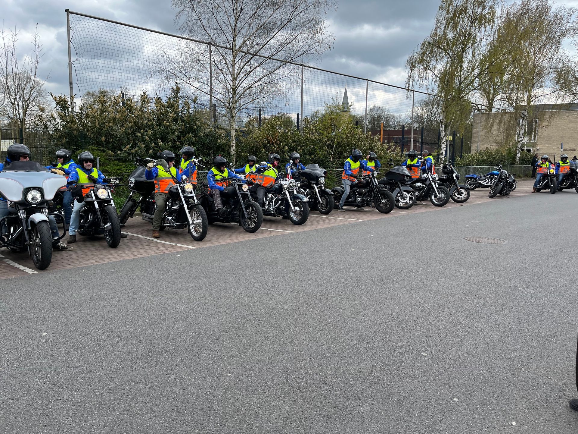 Een groep mensen rijdt op een motorfiets op een parkeerplaats.