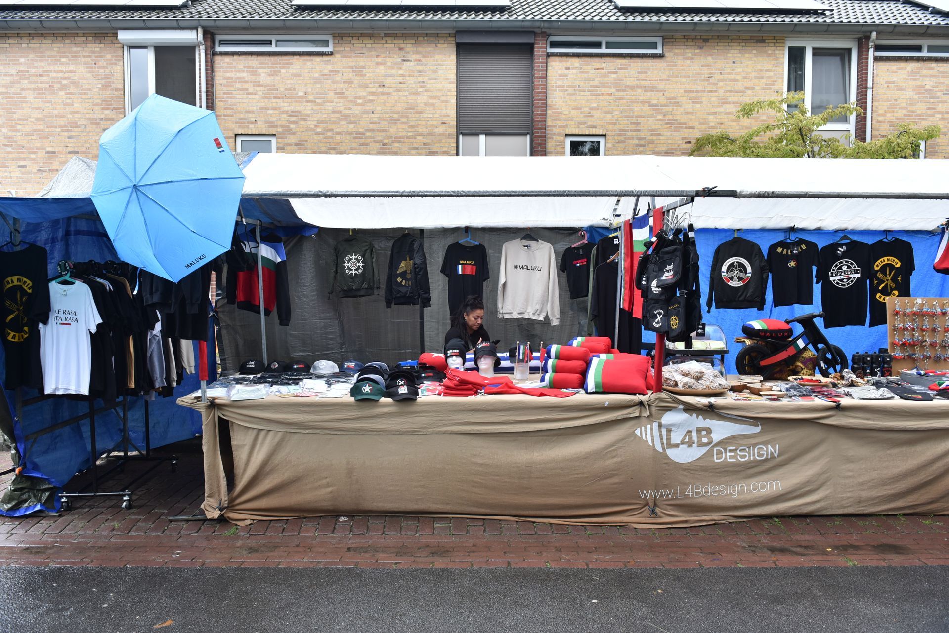 Een blauwe paraplu staat op een tafel op een markt.