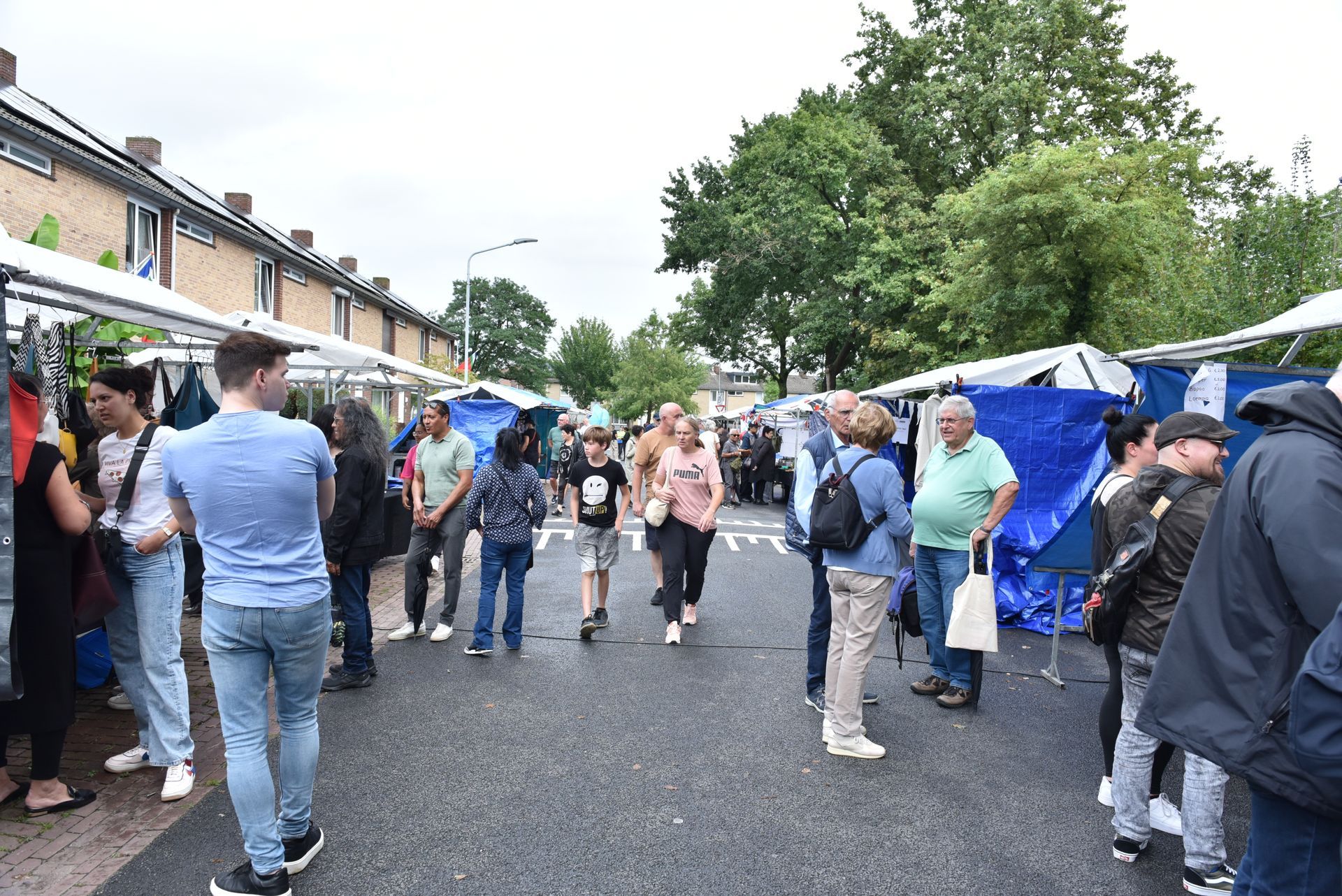 Een groep mensen loopt door de straat op een markt.