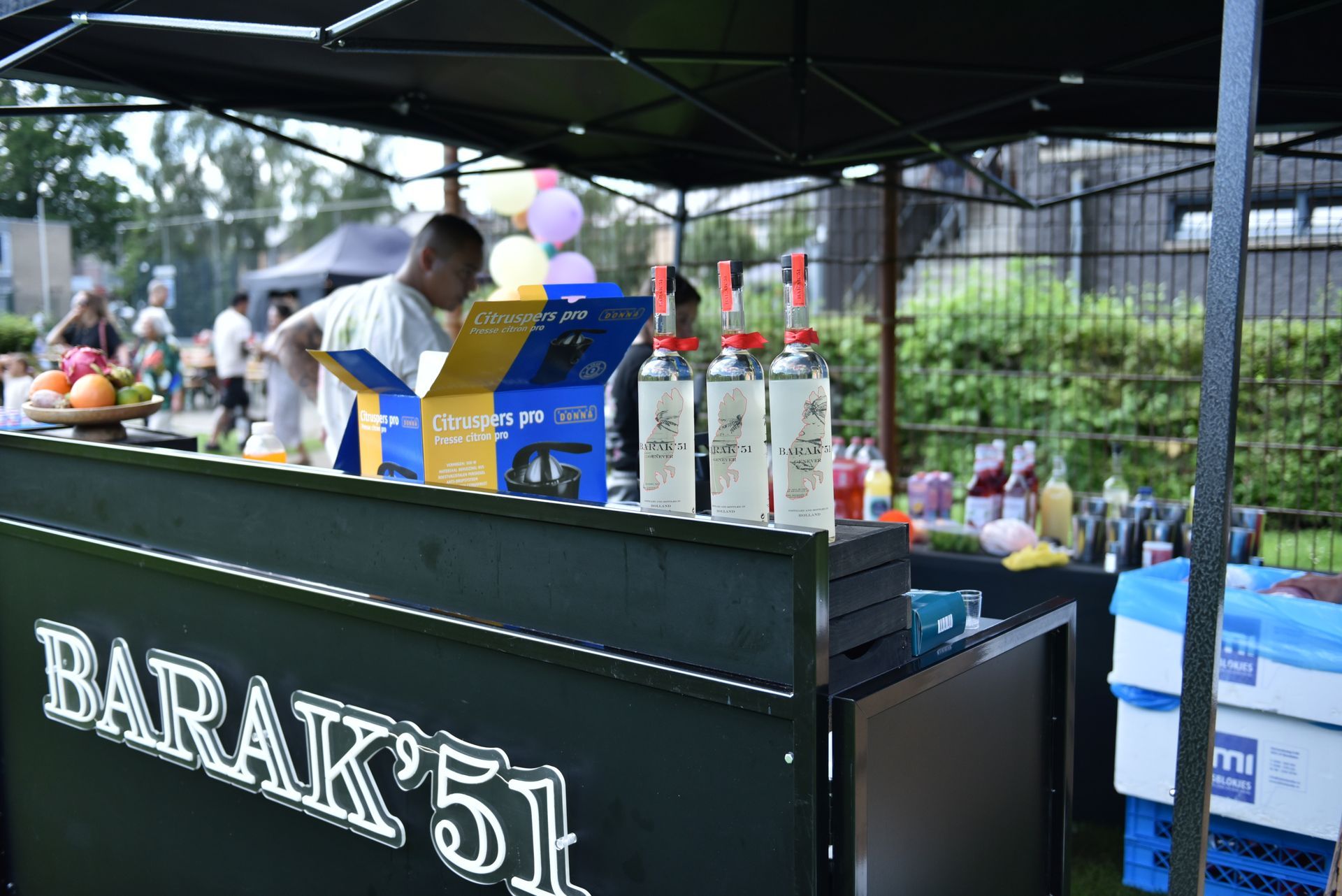 Een man staat achter een bar met de tekst barak 51