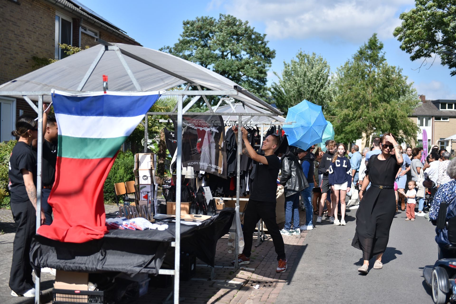 Een groep mensen staat rond een tafel met een vlag erop.