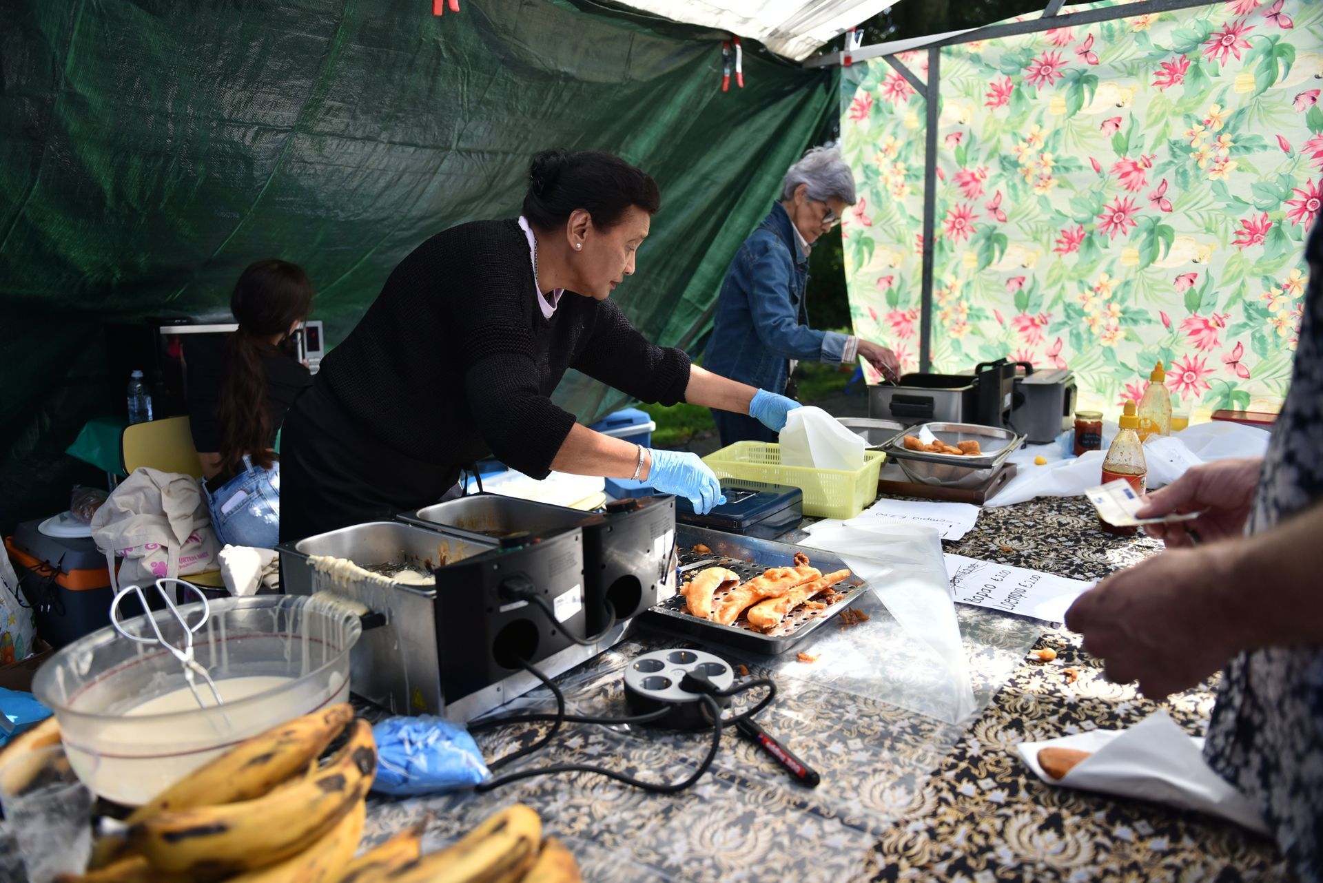 Een groep mensen kookt eten in een tent.