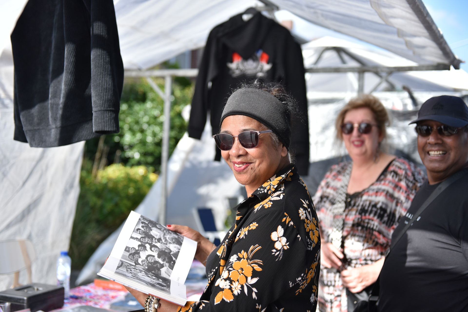 Een vrouw houdt een boek vast voor een groep mensen.