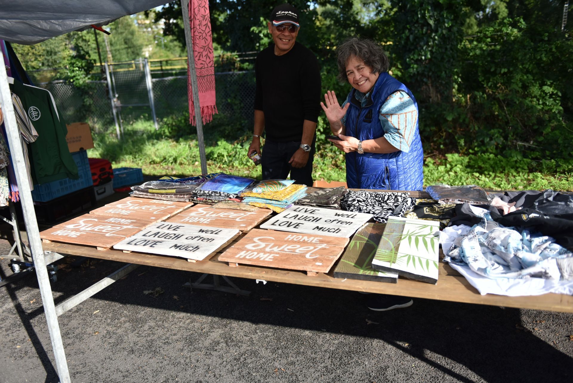 Een man en een vrouw staan ​​achter een tafel met bordjes erop.