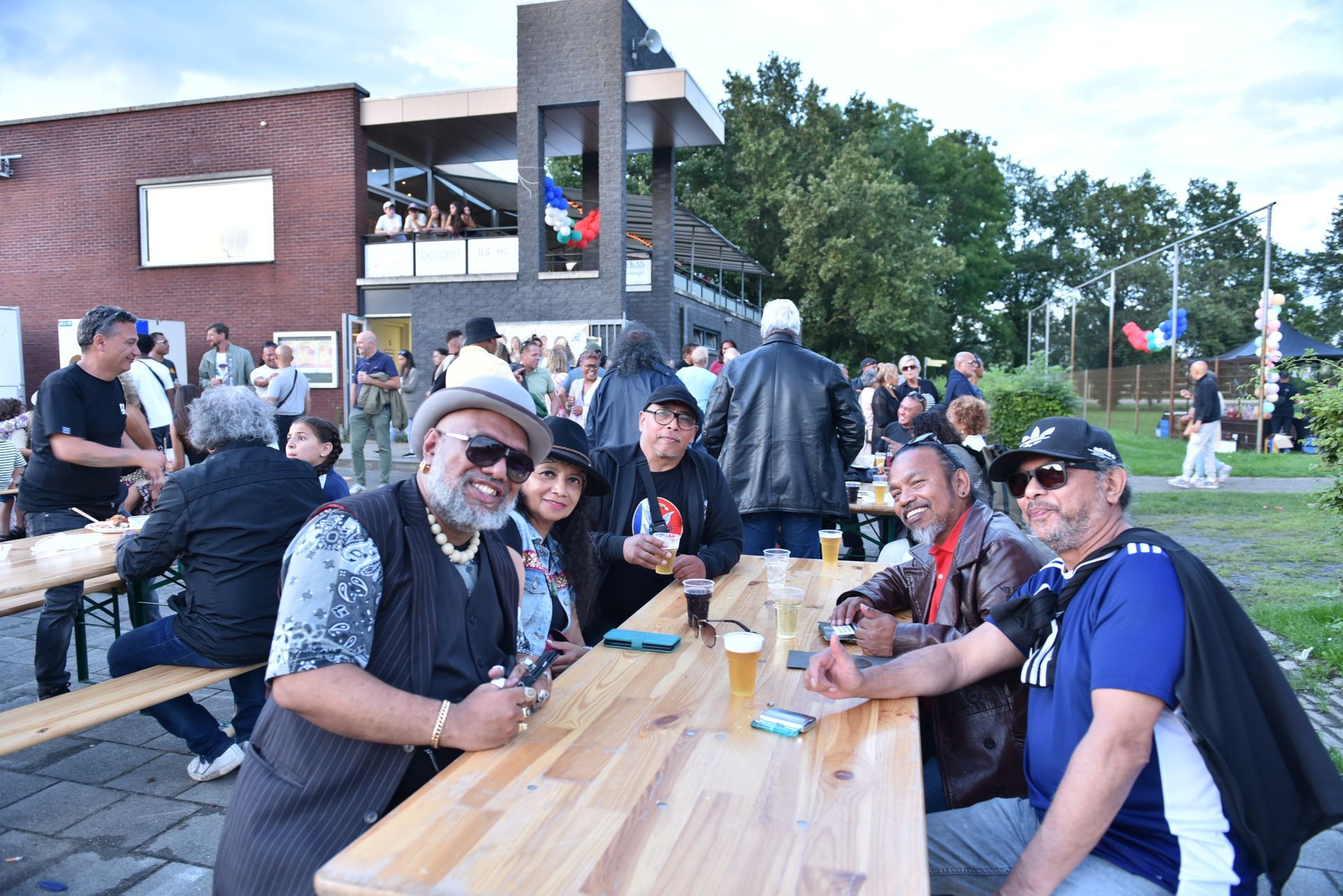 Een groep mensen zit aan een houten tafel.