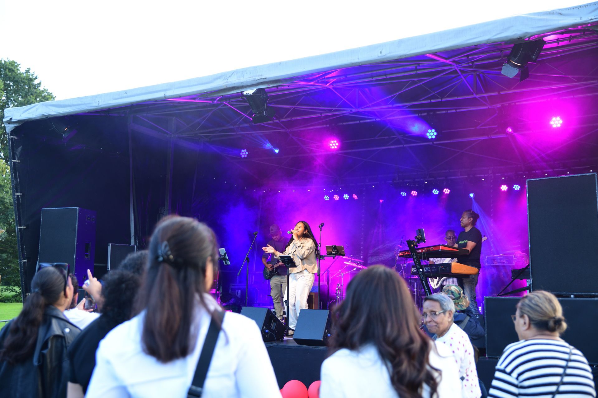Een groep mensen die voor een podium staan ​​met paarse lichten