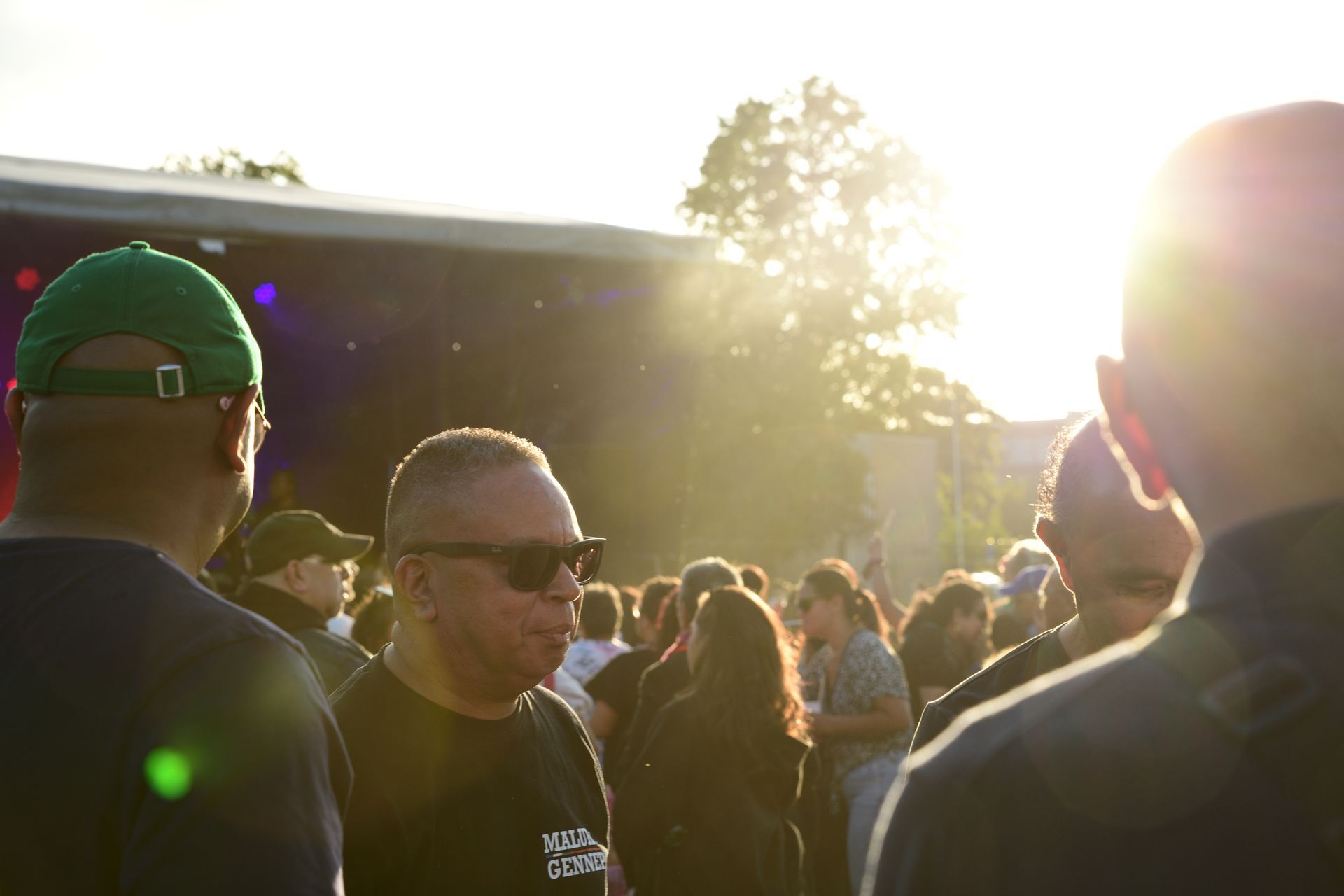Een groep mensen staat tijdens een concert voor een podium.