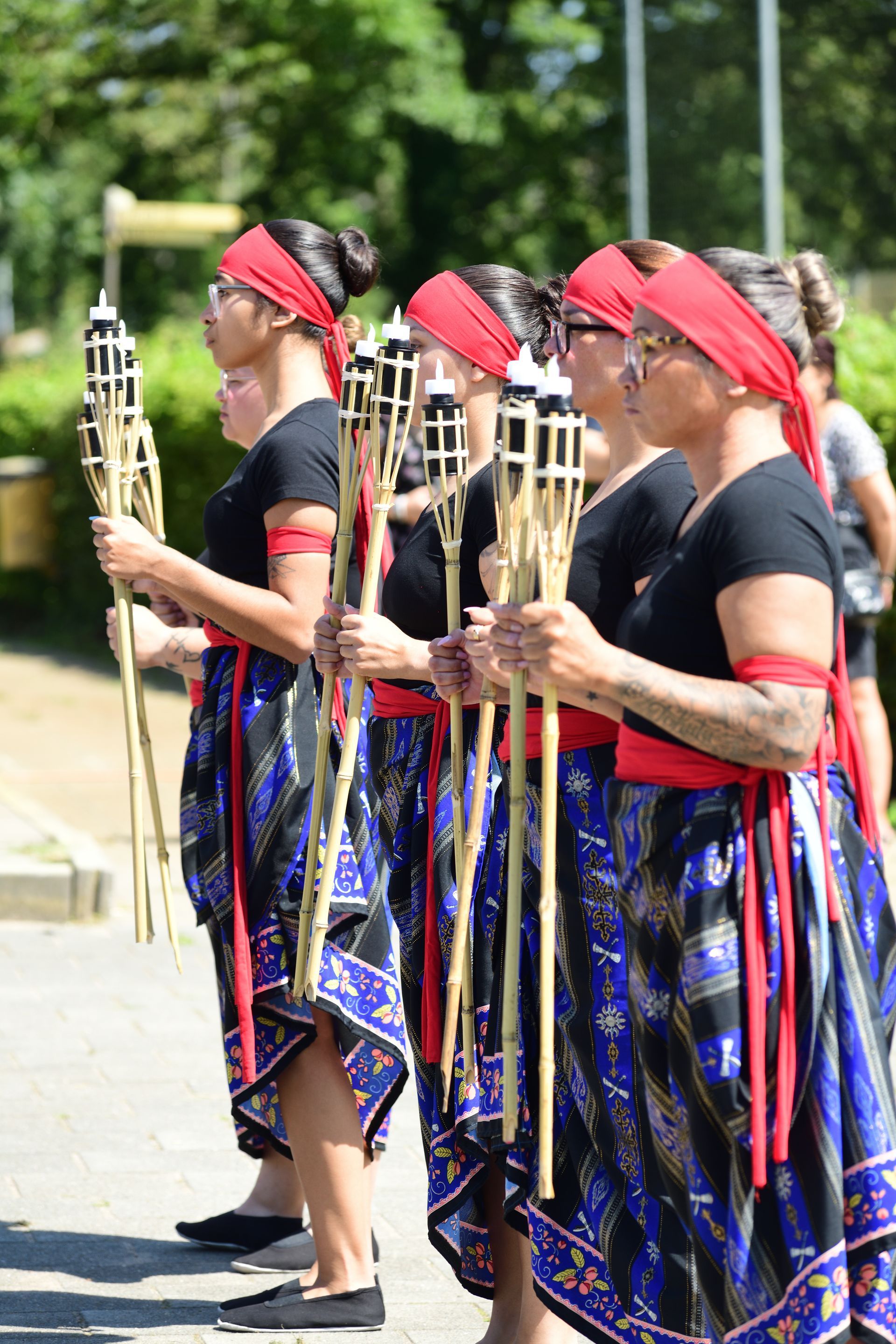 Een groep vrouwen staat naast elkaar met fakkels in de hand.