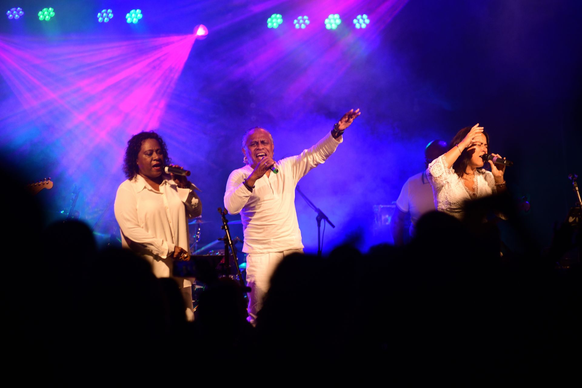 Een groep mensen zingt op een podium voor een publiek.