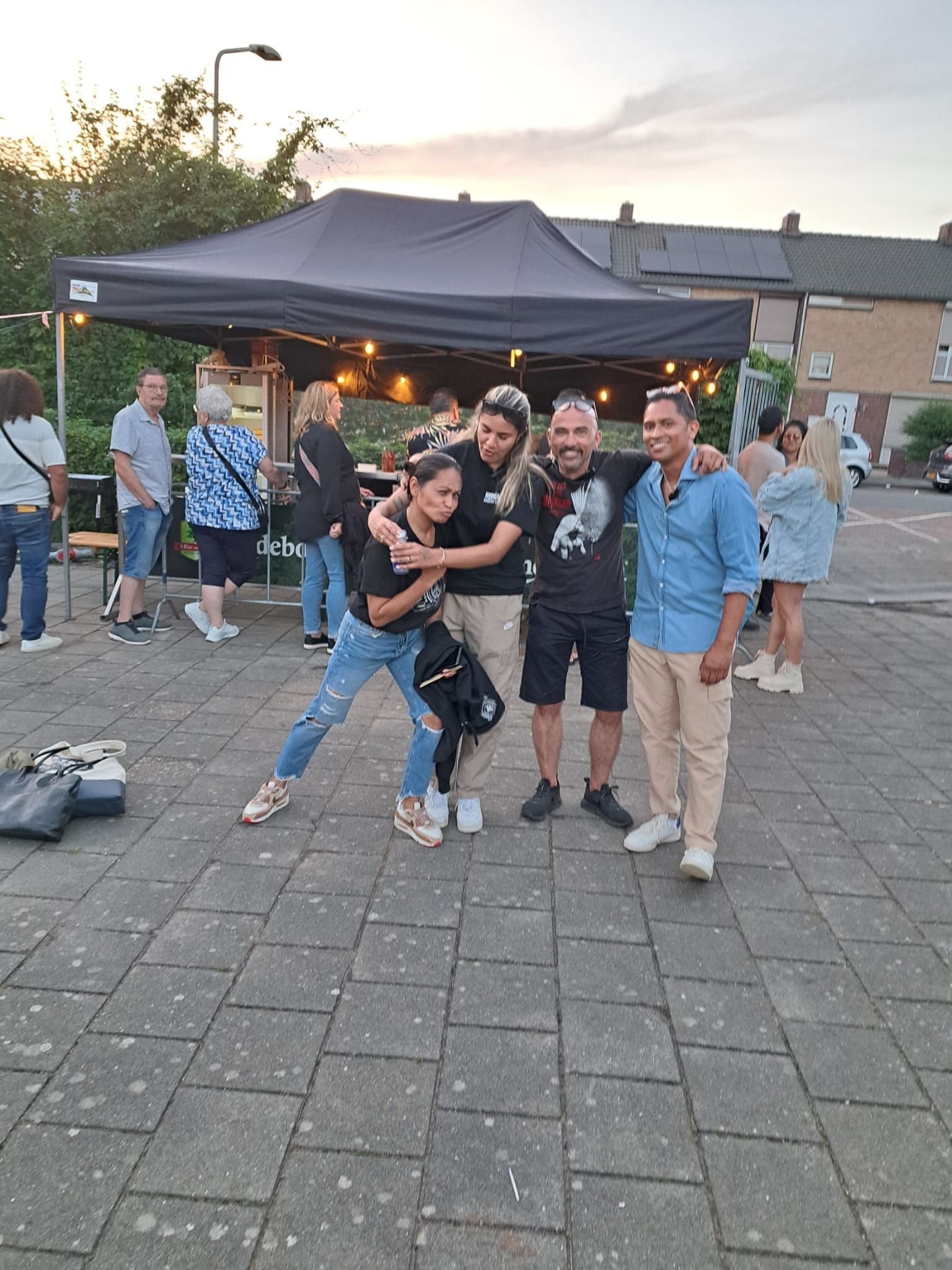 Een groep mensen poseert voor een foto voor een tent.