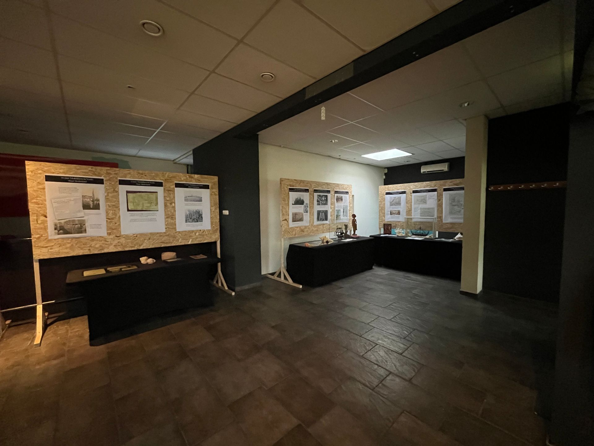 Een kamer met veel posters aan de muur en een tafel.