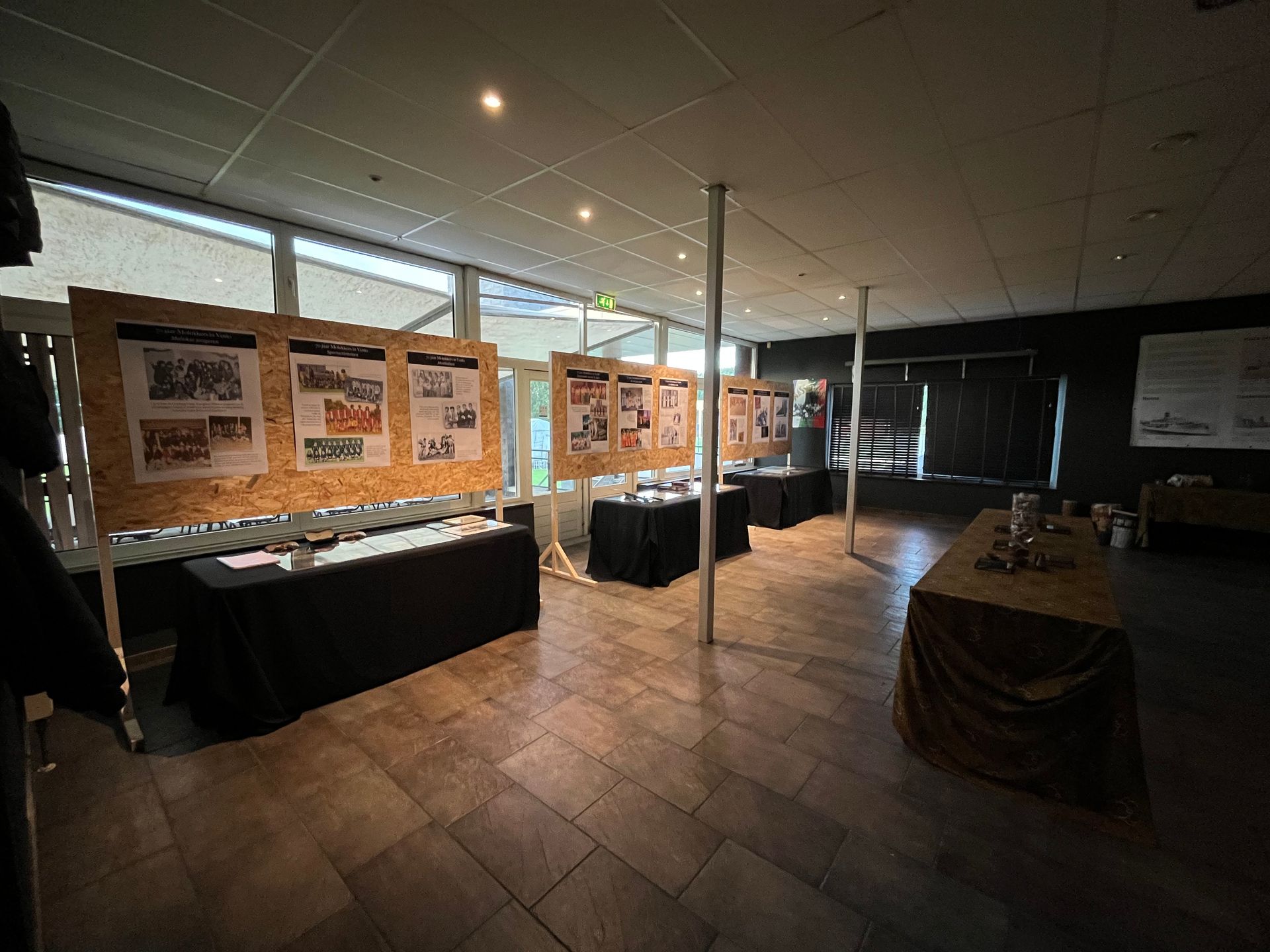 Een grote kamer met tafels en foto's aan de muur.