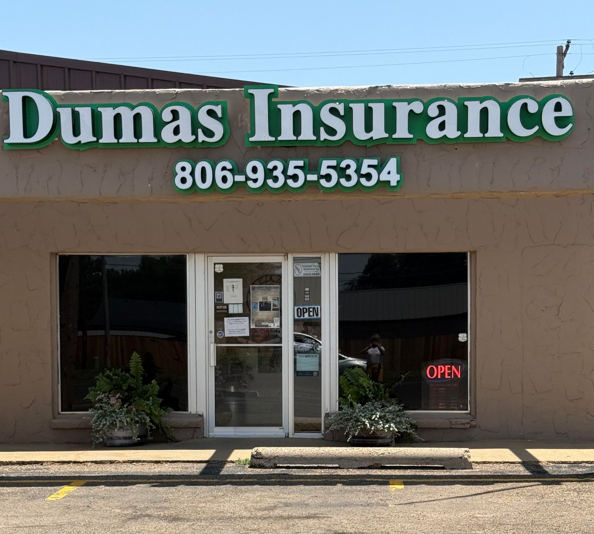 A large family is sitting at a table eating food.