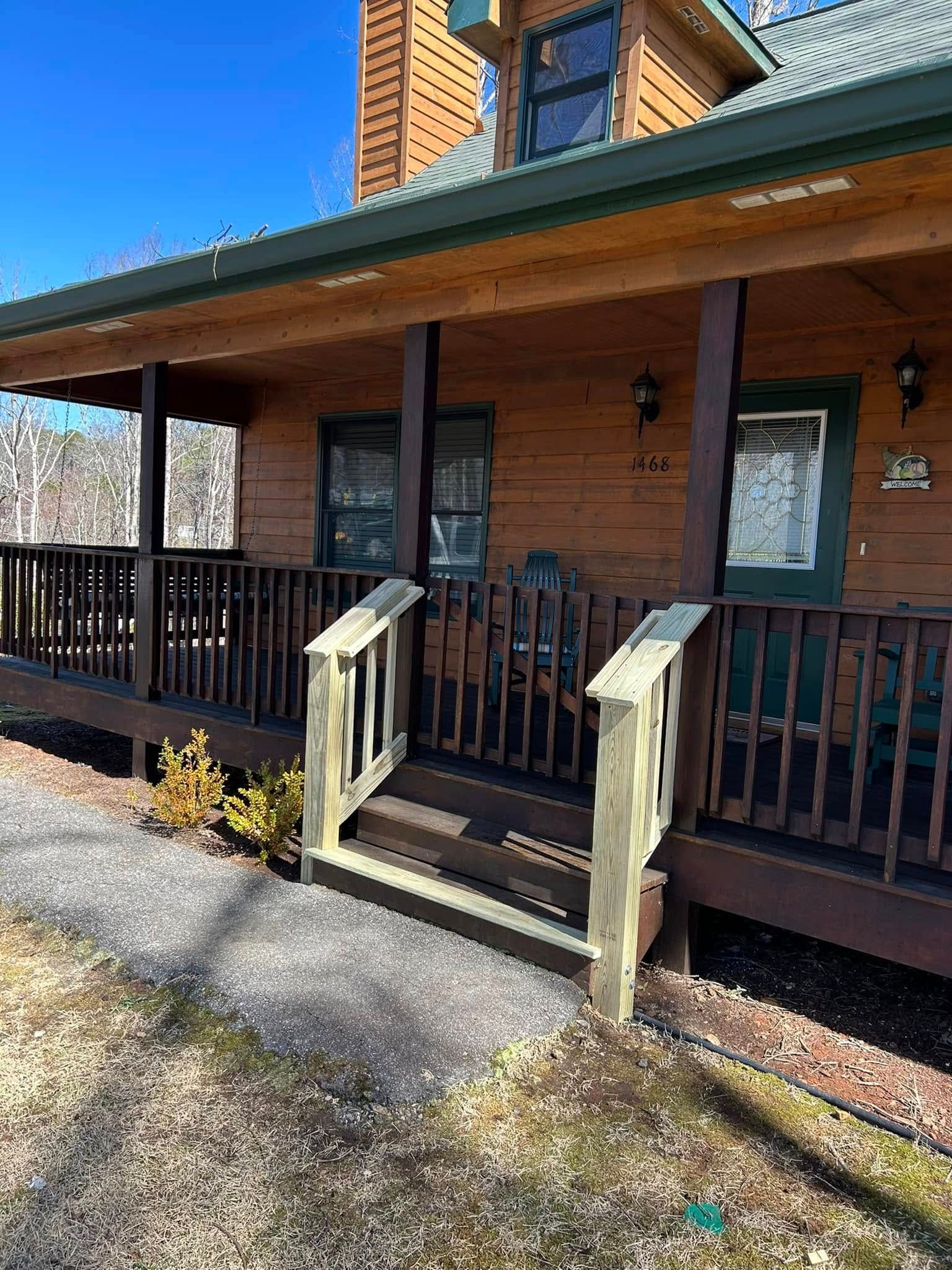 A log cabin with a large porch and stairs leading up to it.