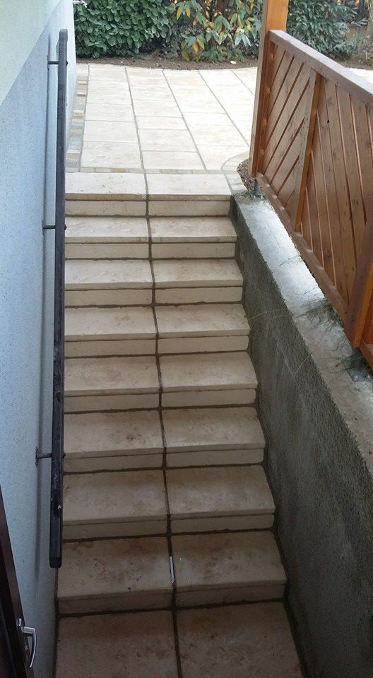 Eine Treppe, die zu einer Terrasse mit Holzgeländer führt.