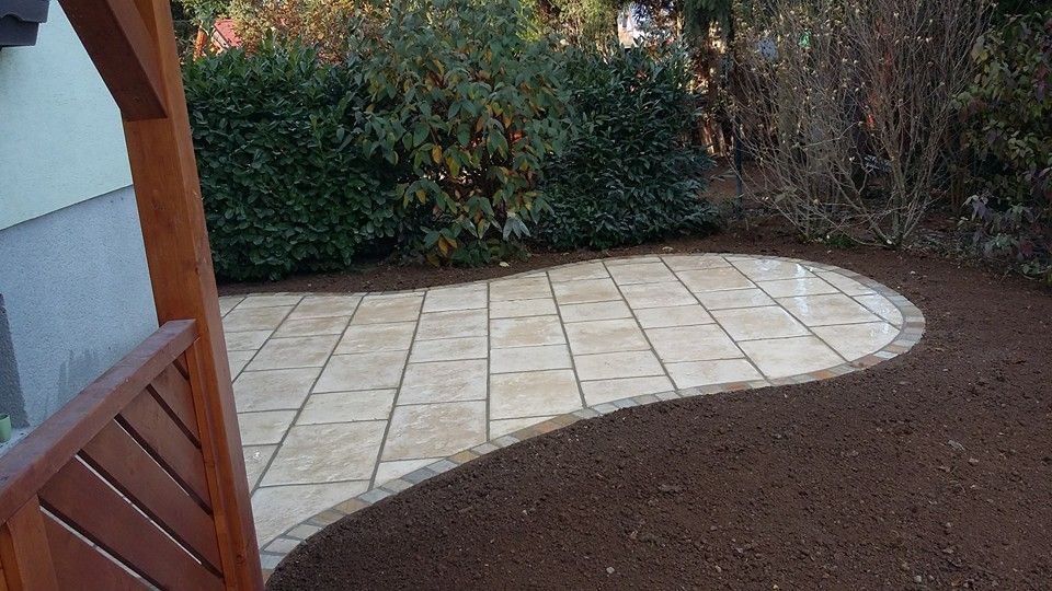 Eine Terrasse mit Holzzaun und ein Gehweg, der zu einem Haus führt.