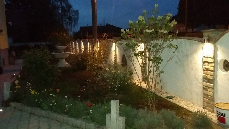 Ein Garten mit einem weißen Zaun und Blumen in der Nacht