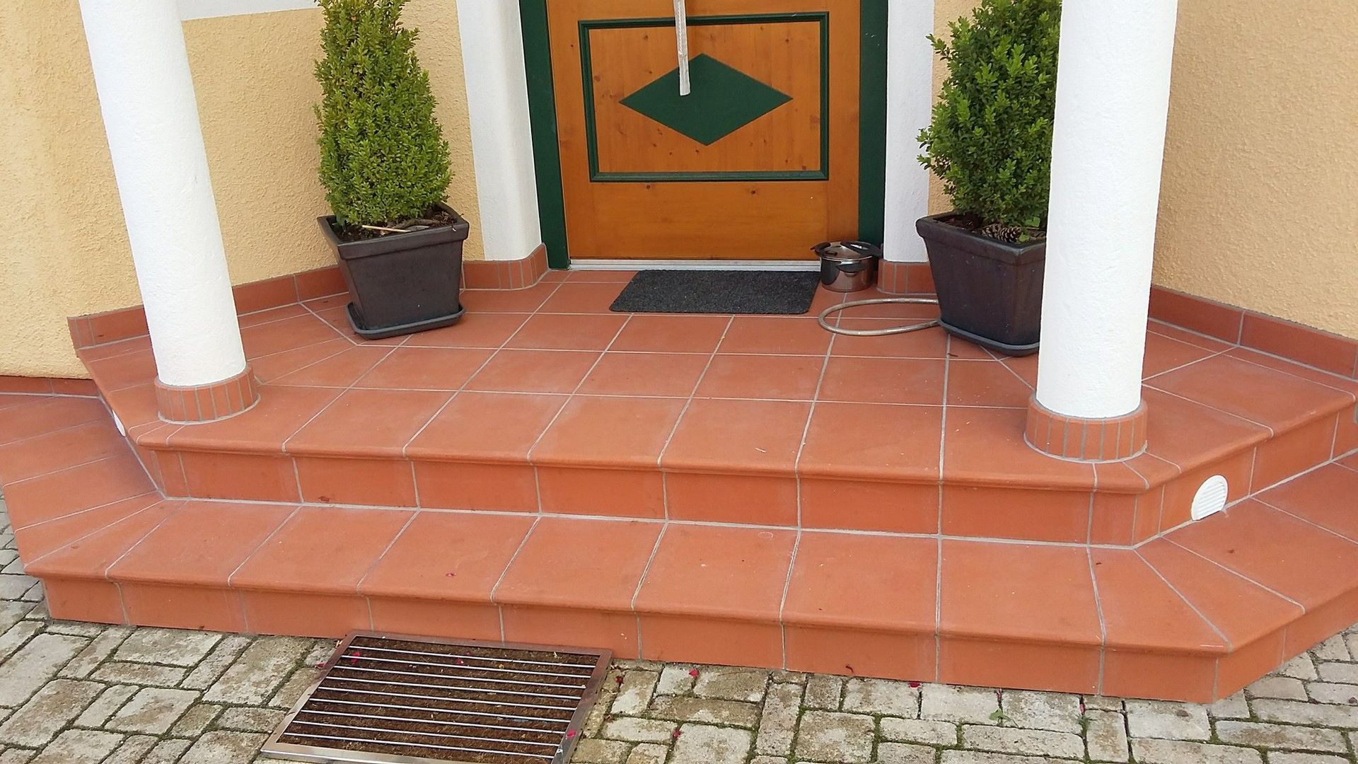 Eine Veranda mit einer Holztür und Topfpflanzen