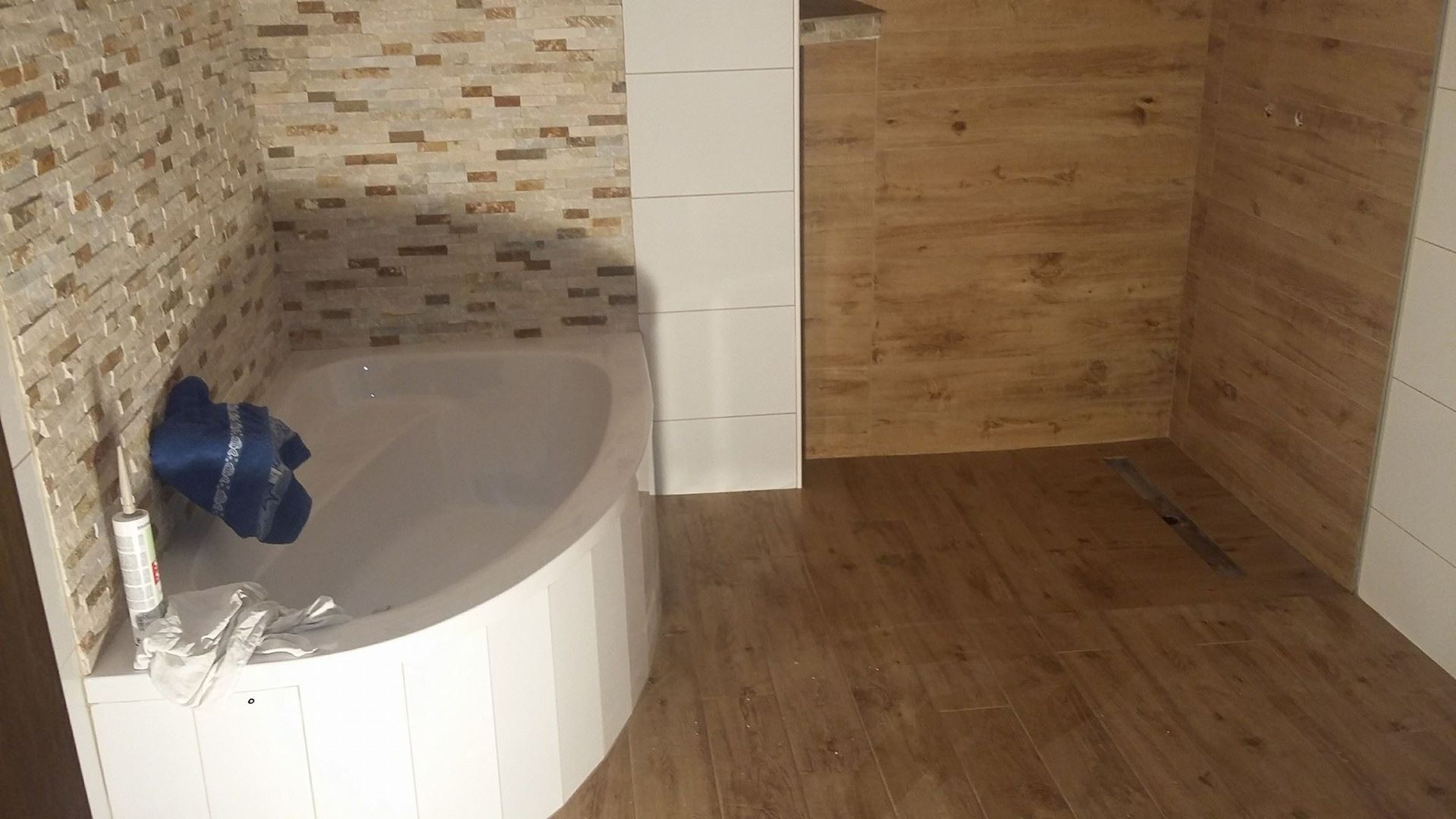 Ein Badezimmer mit Badewanne und Holzboden.