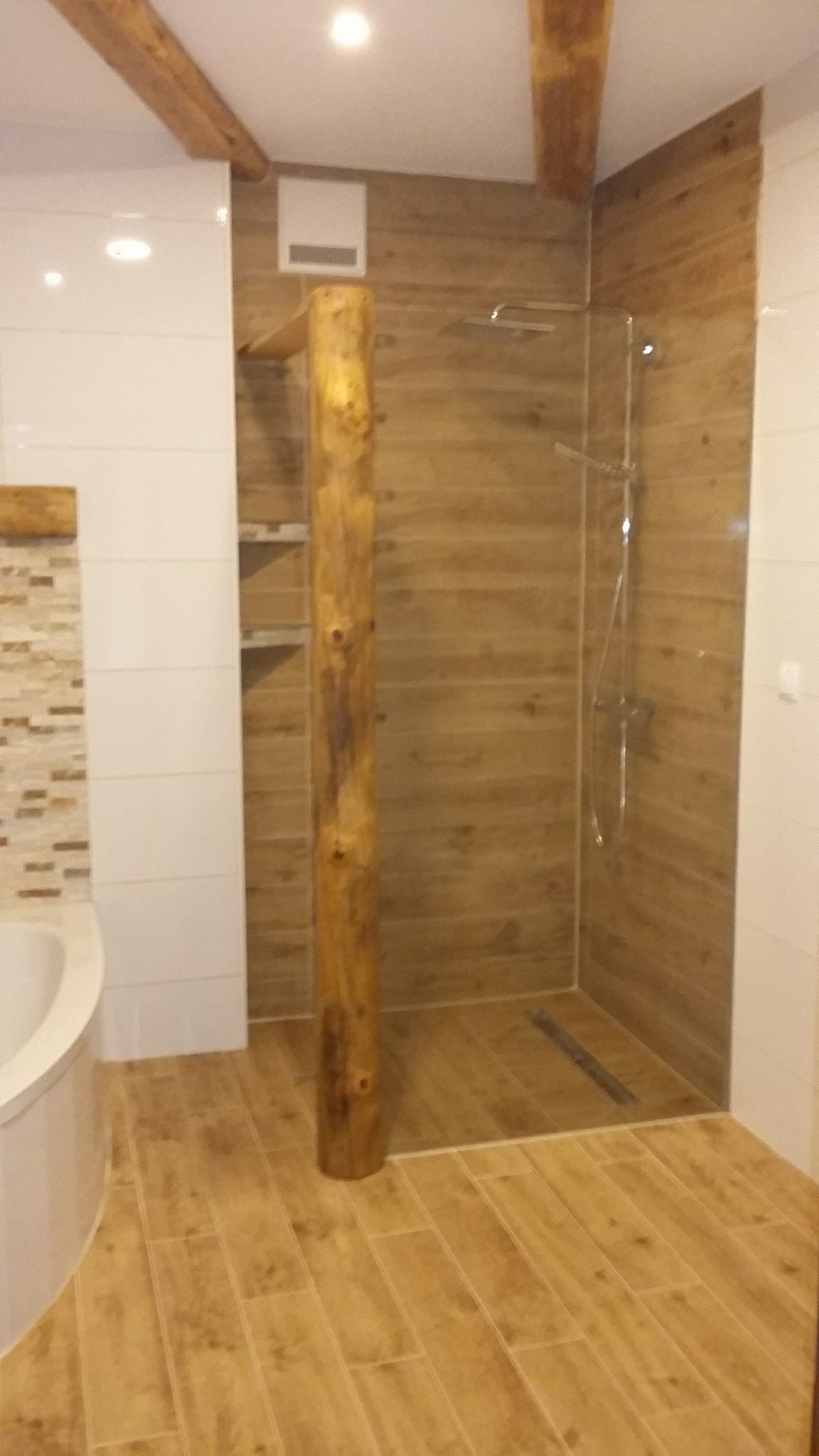 Ein Badezimmer mit ebenerdiger Dusche und Badewanne.