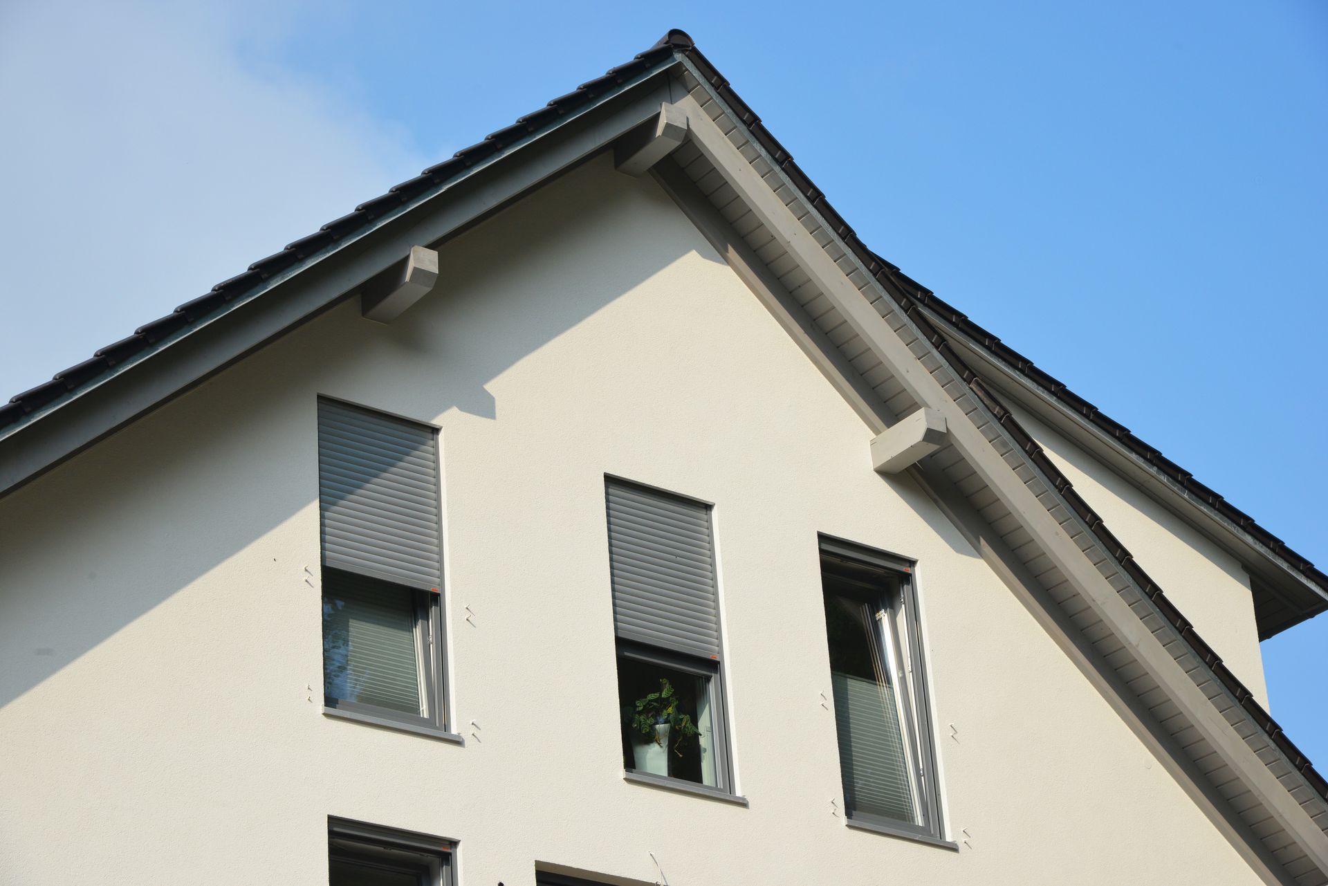 Das Dach eines Hauses mit einem blauen Himmel im Hintergrund