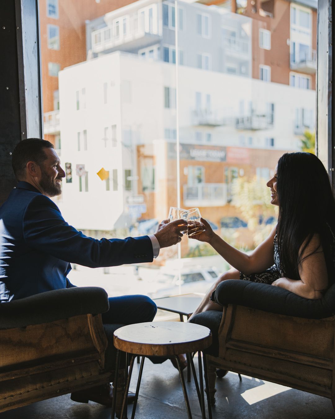 Silhouetted couple kissing on beach at sunset, vibrant orange and blue sky over water.