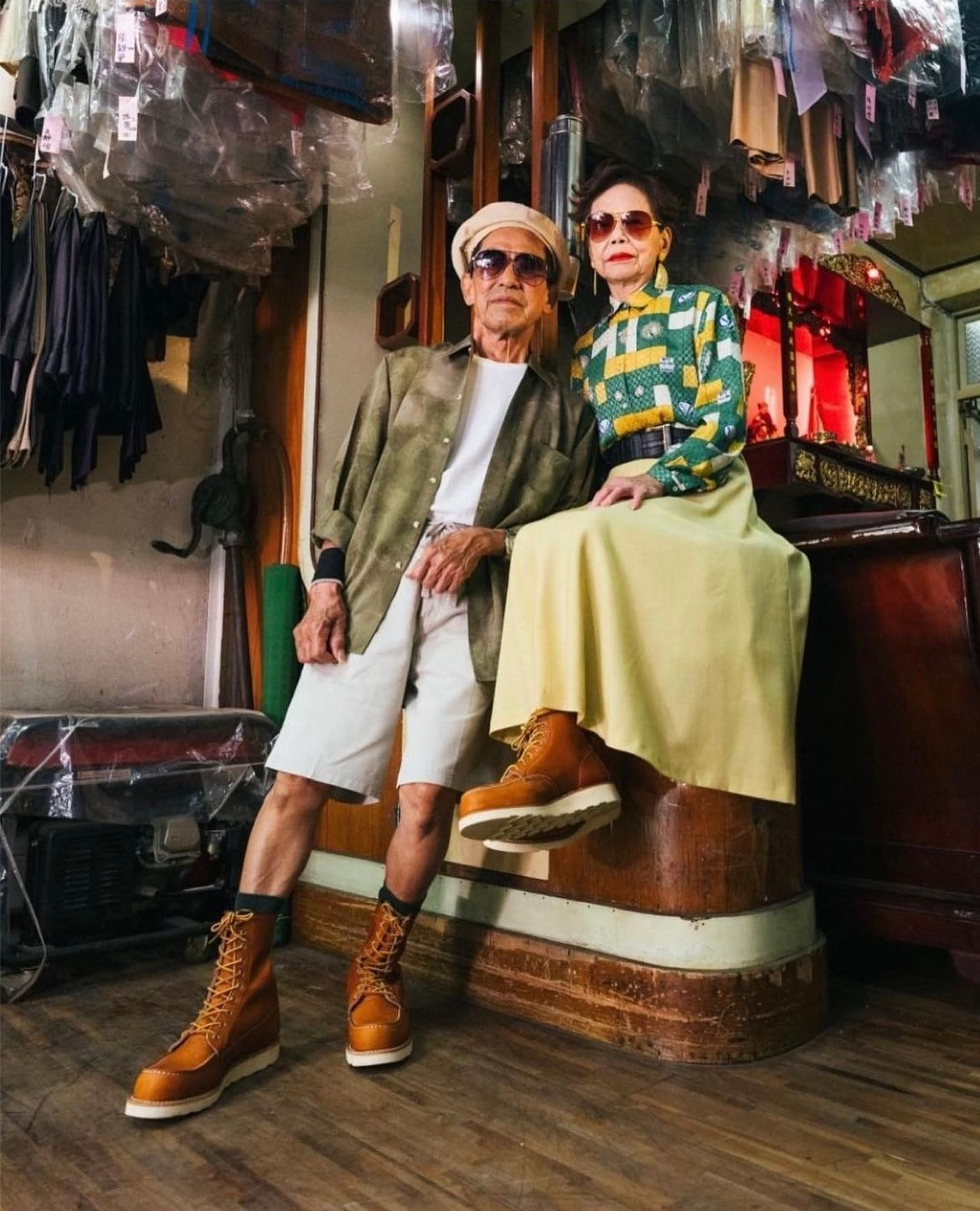 Man and woman in fashionable attire pose in a vintage shop, both wearing brown boots.  Hire a  Matchmaker & Dating Coach 