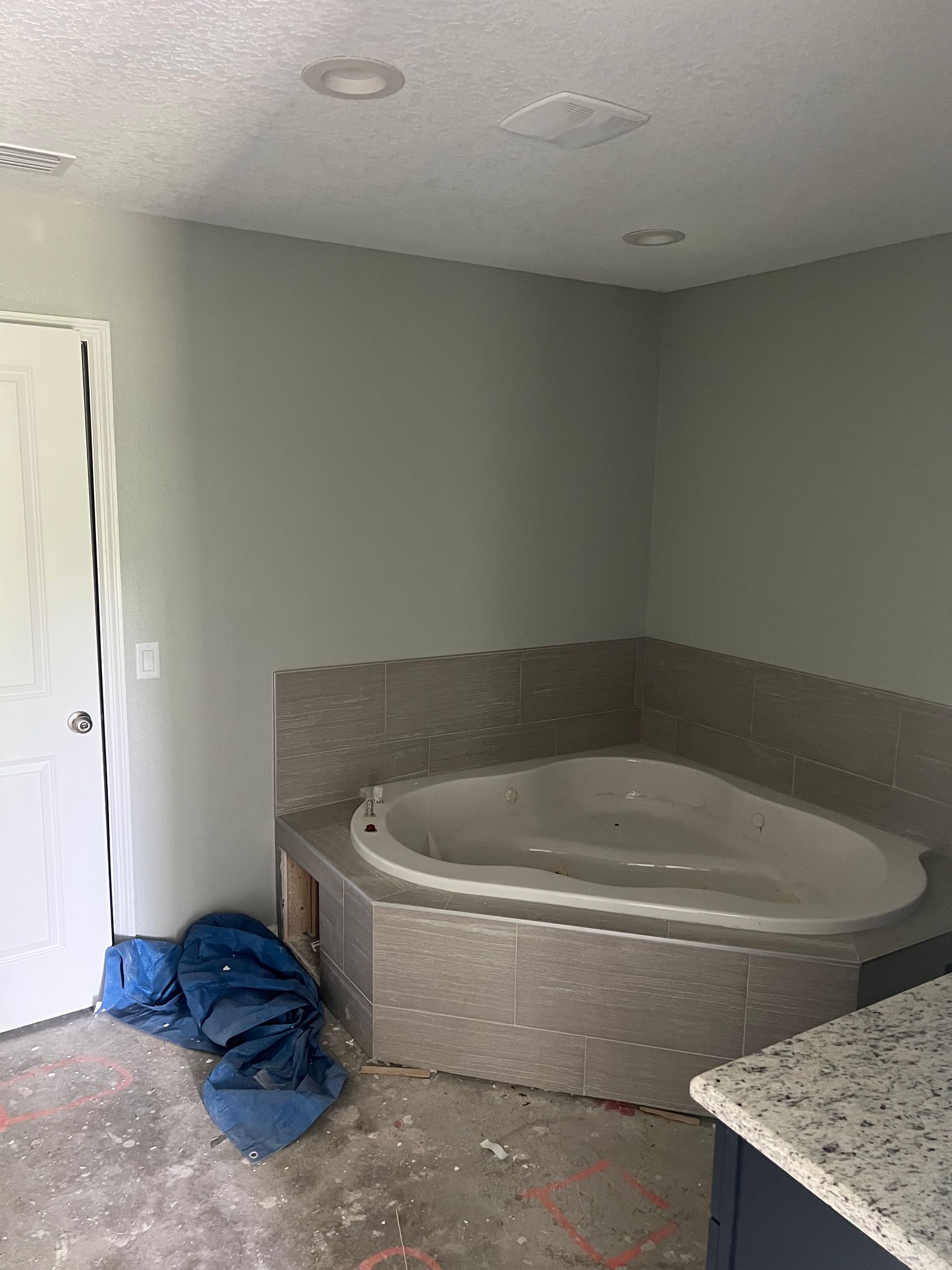 A bathroom with a jacuzzi tub in the corner.