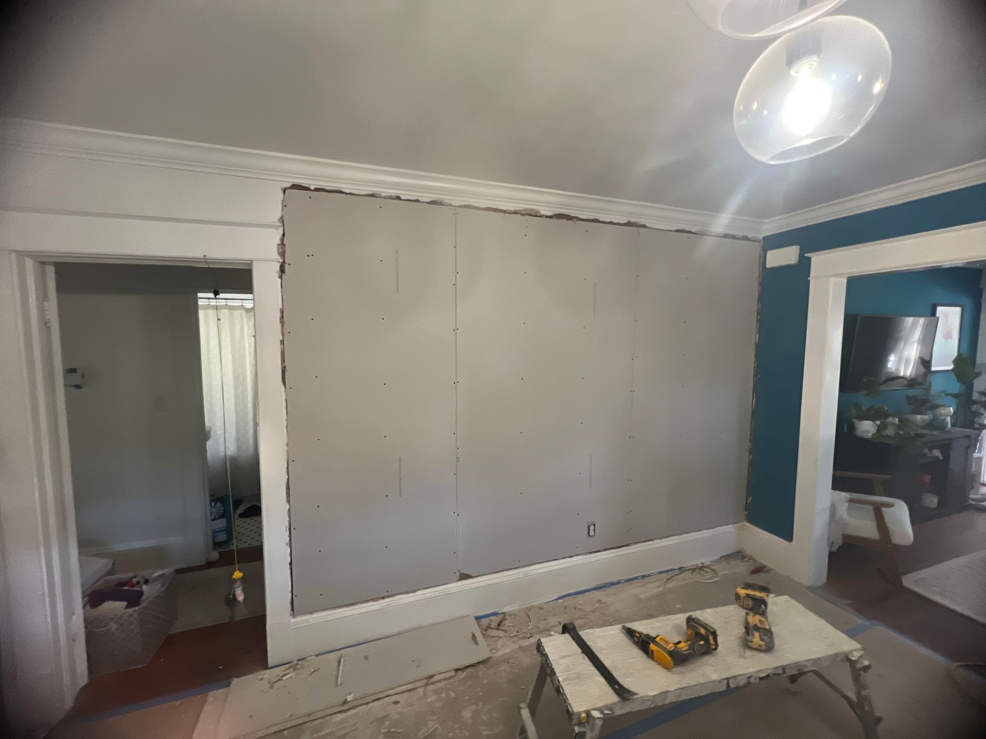 A room with a large wall and a table with tools on it.