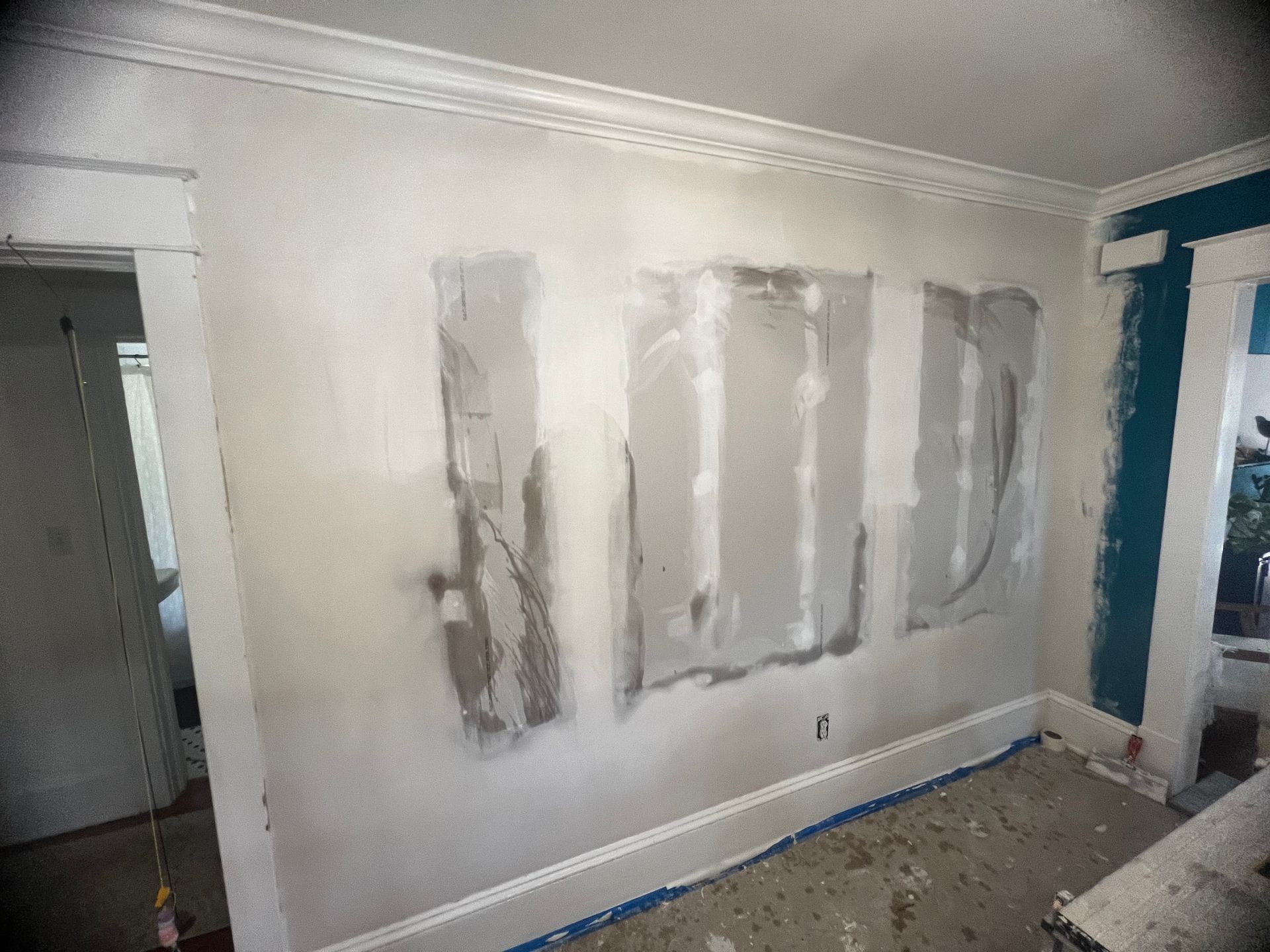 A room with a wall that is being remodeled and the word god written on it.