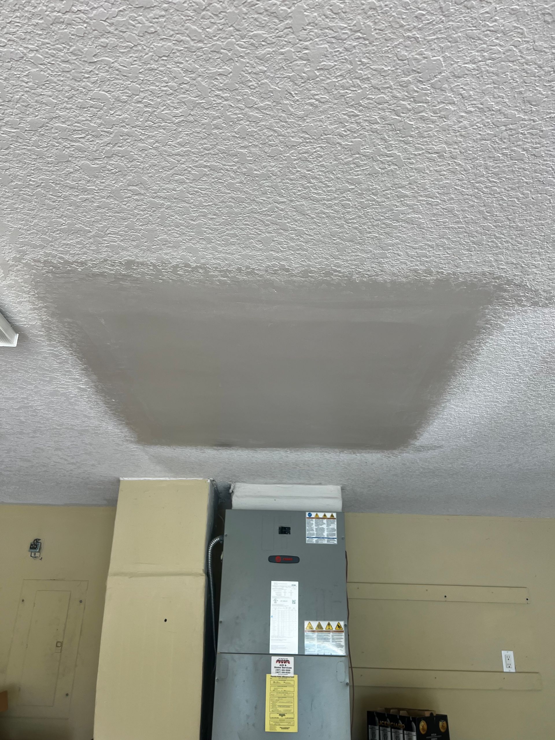 A ceiling with a shadow of a refrigerator on it.